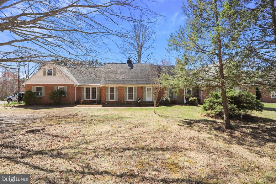 Classic and spacious brick Cape Cod on large corner lot with expansive (1.46 acre) level back yard.  Hardwood floors throughout the first floor that features an open flowing layout with sunroom (with heated floors), formal living and dining, family room with gas fireplace and bright kitchen. Dedicated office with built-in workspace has loads of light and privacy while visually-integrated with the first floor of the home. Perfect for dedicated home office or kids' homework and craft area! Warm natural hardwood floors throughout. First floor primary suite features exercise nook, huge walk-in custom closet, ensuite bath with soaker tub, and sliding glass doors out to a private deck overlooking the bucolic back yard. Second bedroom features ensuite bath. Third room can serve as a second home office or another bedroom. Large first floor laundry room features large front-loading machines and built-ins. Second floor offers two more bedrooms and another full bath. The basement has two sections; one finished and the other unfinished with outdoor entrance. The home has been continuously maintained and offers upgraded systems throughout. The Downs is a sought-after community with stunning amenities including two marinas, a pool, and playground! Convenient to Annapolis and Route 50, Route 97 North, and shopping.