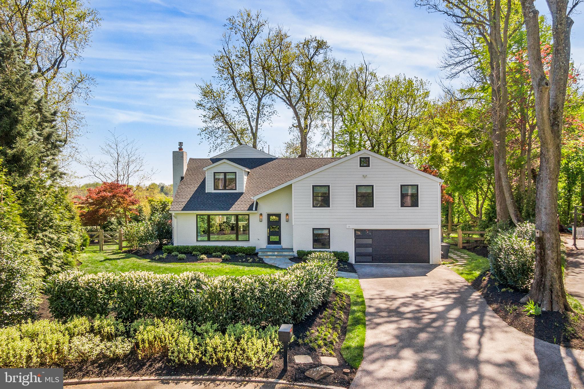 Escape to your own private retreat, where tranquility meets luxury in this meticulously maintained modern home nestled on a quiet cul-de-sac street in Wayne, Radnor Twp. Embrace the serenity of suburban living without sacrificing proximity or space with over 3100 sq. ft of living. This 4-bedroom 3.5 bath property boasts top-to-bottom renovations inside and out. Outside admire masterful landscaping with year-round evergreens, patios, walkways and fencing.
Step inside the living room featuring floor to ceiling windows, a gas fireplace with beautiful slate surround, wide width engineered wood flooring, recessed lighting and scenic views of the surrounding property. The side door leads to a blue stone patio with retractable awning, water feature and more. The great room is open and completely versatile with windows overlooking the lush greenery and nature. This opens to a large gourmet kitchen featuring top-of-the-line appliances, quartz countertops, ample storage, and a dining area with sliding door to another rear patio with a natural gas connection and retractable awning to enjoy tree lined evening sunsets. Step down to the entry level and find a butler pantry with beautiful cabinetry, a large wine cooler, drawer refrigerator, dishwasher, and plenty of storage. This level features a laundry area, powder room and mudroom with access to the rear patio, attached two car garage and a large storage closet. Ascend upstairs to the living quarters and find three bedrooms all with matching wood flooring and recessing lighting. The one bedroom features an ensuite bath and custom closet cabinetry. There is another hall bathroom with tub/shower combo and beautifully appointed fixtures and lighting. On the next level, retreat to the luxurious primary suite with a spa-like bathroom with soaking tub, shower, double vanity and custom cabinetry. There is an office suite/studio with a custom sliding barn door and a separate yoga area. The sleeping area includes beautiful views morning and evening all year round. This level also includes a laundry closet with hook-up for a stackable washer/dryer and a walk-in clothes closet with built-in drawers and more. Simply put, this home seamlessly blends the allure of natural surroundings with the comforts of modern living, offering a lifestyle of unparalleled tranquility and convenience.