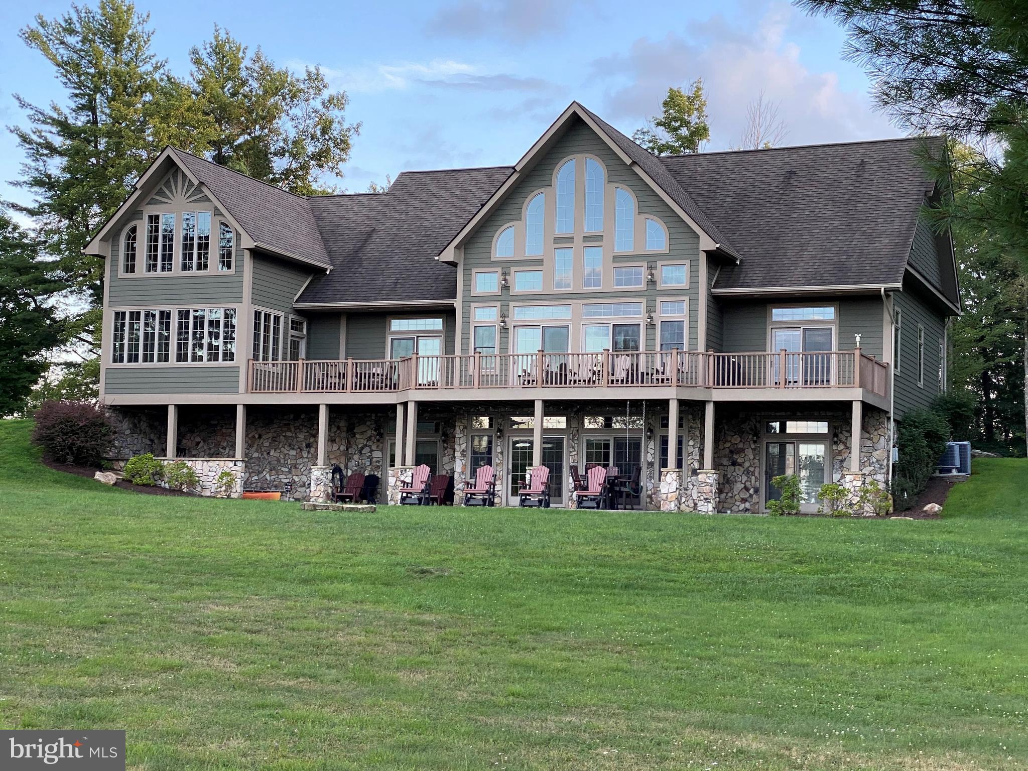 The Reserve at Holy Cross occupies its own peninsula of lakefront and lake access homes that enjoys the privacy of a non-rental community through its covenants. LOCATION is remarkable. Only 5.7 miles to the Arrowhead area on US 219 - easy commute to resort amenities, restaurants, conveniences and in 11 minutes, return back home to a serene and private retreat. Seasonal Views. Very close by is your access to (2) deeded dock slips. The waterfront location is great for swimming, canoe / kayaks, fishing and just simply enjoying Deep Creek Lake. Indoors, gathering in the great room and gourmet cooking in a 15 x 15 kitchen is delightful. With 5,200 +/- of finished living space, home has 3 Au Suites. The first one is on the Main Level that promotes one floor living. There is a washer dryer on this level along with the 2 Car Garage, Kitchen, Living Room, Dining, Foyer with sliding doors to an expansive deck that connects to an outdoor screened porch. The 2nd Au Suite has the entire floor of the Upper Level: with its own Living Room in the Loft (fabulous views), and a very large bedroom that has French doors that open to a private sitting area with flexible use. This area is supported by its own Rinnai Tankless water heater. Check out the photos to view the extra large private bathroom. The Lower Level has the 3rd Au Suite with its own private bath. There are 2 additional bedrooms each with its own full bath on this same lower level. In the center is a 24 x 22 Game Room (with 2nd fireplace) and wet bar. 2nd set of Washer and Dryer on this level. All 3 Au Suites have very large bathrooms with a separate Shower and Bathtub. ENJOY the Radiant Heat Floors. Deep Creek Lake enjoys an elevation of 2900 +/- ft above sea level. Evening bonfires are undisturbed by bugs that prefer humid weather. This Four Season Lake is special. Whether it be living indoors or outdoors in this special place you can call home, it is truly perfect for a second home and year-round living. HOA Dues are as shown plus with 2 Dock Slips - if using only one slip - additional $160 paid for permit. If using both dock slips + $320 annually = to (2) Dock Permits.