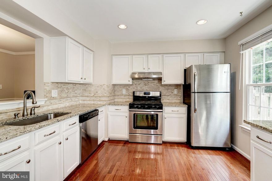 Remodeled 3 finished level TH with new full baths, roof, water heater, and freshly painted. Hardwood floors throughout sun filled main level. Updated kitchen w/ granite, SS appliances, 5 burner gas range, tons of counter space, eat in breakfast area w/ atrium doors to newer back patio and landscaped, fenced back yard. Spacious lower rec room with 1/2 bath and a lot of storage space. Move in ready