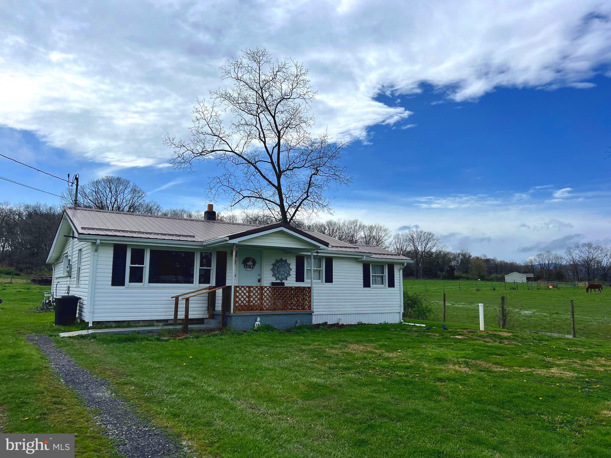 Abutting a farm with horses and cattle, you can enjoy the setting and view, while less than a mile from town!
Nicely remodeled rancher with 2-3 bedrooms and one bath that was recently remodeled beautifully with marble surround rain shower. Public water and private septic. Fiber Optic available.Enclosed back porch/mud room/laundry with storage area. Looks are deceiving, as this is larger than it appears from the outside! New flooring , New metal roof. New cabinets in kitchen. Huge garden space in back yard to grow your own vegetables. Views of distant mountains from anywhere on property! Looking for affordability close to town? This could be the one for you with a little TLC to make it your own.