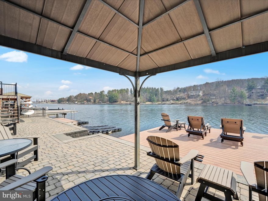 This listing features a charming, fully updated and reasonably priced 4BR/3BA raised ranch lakefront property on 0.5 acre with stunning views. Located in the gorgeous, gated, Lake Wynonah Community, this versatile and well-maintained home with 2-car garage, circular driveway, paved waterfront path and newer bulkhead and dock is a must-see. The lake views from the kitchen, living room, two bedrooms, deck and patio are framed and amplified by gorgeous, tall pines. The layout is designed to maximize space and natural light, and the fresh, neutral paints create a bright and airy atmosphere. The custom kitchen with large peninsula, coffee bar and separate wine bar is the perfect space to host family gatherings and entertain friends. 6 newer barstools included in sale. A built-in, granite desk graces this space to offer even more functionality. The kitchen and living room flow seamlessly together to enhance the open floor plan, and vaulted ceilings offer architectural character. Two custom bathrooms with honed granite and two bedrooms complete the main floor. Two additional bedrooms with lake views and Anderson sliding glass doors plus a bonus office or workout room, bathroom and family room adorn the lower level, offering well over 2000 square feet of total living space. The family room was updated with drywall ceiling, recess lighting and fresh paint in February 2025. Laundry area in basement with granite folding table and new pine wood washer/dryer enclosure. Laundry area can be finished with drywall if desired. The entire home is tile plank flooring; easy to clean, maintain, and extremely durable. Solar is leased through Sunnova, and offers reasonable electric. The waterfront with a plethora of gorgeous landscaping is completely finished and boasts EP Henry bulkhead and paver dock. Kayak/paddleboard racks, shed and gazebo included in sale. 16X16 fixed, composite dock. Notable features include: roof and entire home renovated in 2020 and on, newer propane fireplace, owned propane tank, epoxy paint patio and flagstone firepit area overlooking lake, cable wire deck railing, composite decking, paved circular driveway and path to waterfront, active radon mediation system, on-site septic.  Lake Wynonah is a gated, lakes Gold Star community, featuring 2 gorgeous, pristine, spring-fed freshwater lakes (Lake Wynonah is approximately 90 ft. deep and Fawn Lake 45 ft. deep at deepest areas). Amenities include: business office/gathering room/library, lodge w/dining and bar, social clubs, boating, fishing, wakeboarding, waterskiing, tubing, paddleboarding, tennis, pickleball, several parks/pavilion, basketball courts, horseshoe pits, 2 pools, beautiful docks, hiking, natural wildlife and marina. Groups and events include: Active Civic Association, Dances/Concerts, Book Group, Pinochle Group, Volunteer Programs, Fish & Boat Group. Located less than an hour from Allentown, Harrisburg, Hershey and Reading. Close to Philadelphia and surrounding suburbs. Beat the beach traffic and settle in at the lake. Lake Wynonah is "Life On Vacation"!