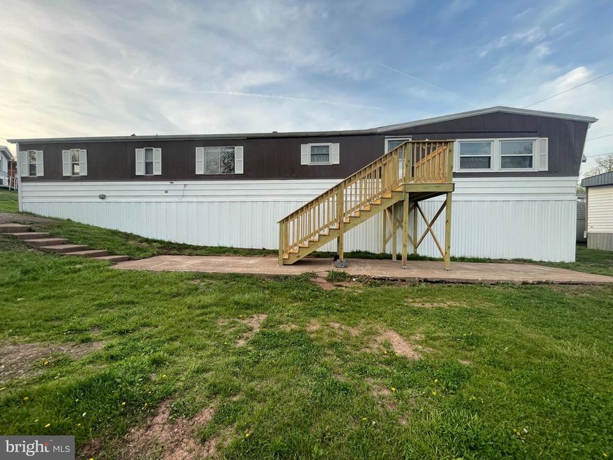This completely modernized 2-bedroom, 1-bathroom residence sits on a corner lot providing the owner with lots of land to call their own. With the large concrete porch, be the envy of your neighborhood when you cook out with your family and friends during those lazy days of summer. This move-in-ready home boasts an brand new double-element 40 gallon water heater, lots of closet space and kitchen cabinets, washer, dryer, electric stove and refrigerator.  The opportunity stands out with its low ground rent and a prime location that puts local dining and shopping close by. From the moment you arrive, the sturdy new outdoor steps signal a property that has been maintained with care.
Step inside to find a bright, inviting interior featuring all-new paint and new light fixtures that create a contemporary atmosphere throughout the home. Whether you are hosting friends or enjoying a quiet evening, the central air ensures the space remains comfortable regardless of the season.
The all-electric home provides reliable energy and with nearby gas lines, you have a future option of connecting to natural gas. This turnkey home provides an ideal blend of modern aesthetics and functional efficiency. Park approval is required, and the seller is open to considering all offers. Don't miss this opportunity for affordable, updated living in a convenient community setting.