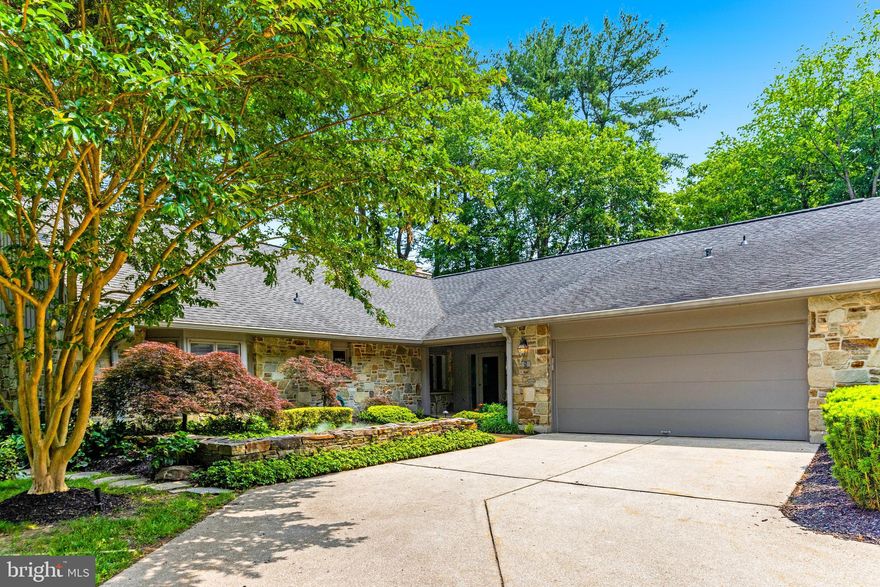 Located in the prestigious gated Rockland community, 5 Tall Tree Court is a beautifully designed stone and board-and-batten residence featuring 3 bedrooms, 3/1 baths, and an impressive 3,000+ square feet of living space. A charming covered front porch welcomes guests to the property, where meticulous landscaping and stone garden walls set the tone for the beauty within. The spacious, welcoming foyer opens to the living room, where a beamed ceiling and a stunning stone fireplace create an inviting atmosphere. Built-in bookcases, an illuminated alcove, and access to the patio highlight the thoughtful design. Flowing seamlessly into the dining room, this space is ideal for entertaining. The adjacent kitchen features shaker-style cabinetry, marble-finish quartz countertops, and premium stainless steel appliances, including a GE French door refrigerator and KitchenAid double ovens. An attached breakfast area with a picture window offers a casual spot to gather, while an open staircase provides access to the upper level. The main level also boasts a luxurious primary suite, offering a private retreat with wood floors, built-in storage, and two custom closets. The suite includes a spa-like bathroom with a soaking tub, dual vanities and a separate shower. Additionally, an adjoining private study with built-in bookcases and bay windows, as well as a versatile second bedroom or den, provide ample living flexible living space. A powder room, laundry room, and a finished two-car garage complete the main level. Upstairs, the third bedroom is a serene and private space with a walk-in closet and a beautifully appointed en-suite bath with a granite-tiled shower and river rock flooring. Outside, the home’s bluestone patio serves as the ultimate outdoor oasis and contains a built-in gas line for grilling. This .25-acre lot is perfectly situated within Rockland, allowing residents to enjoy the community’s many amenities, including tennis and pickleball courts, a fitness center, an outdoor pool, and a clubhouse with a guest suite. With its convenient access to expressways, shopping, and entertainment, 5 Tall Tree Court is a true gem.