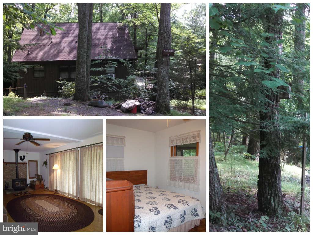 Newly painted interior! This charming 3 bedroom, 1.5 bathroom cabin in the woods, situated on 3 acres, offers a great location, beautiful setting and amazing views. Enjoy relaxing or entertaining on the wrap around decking and screened in porch while listening to the stream below or enjoy the views and sounds of nature on the upper level balcony. Offering many unique features.