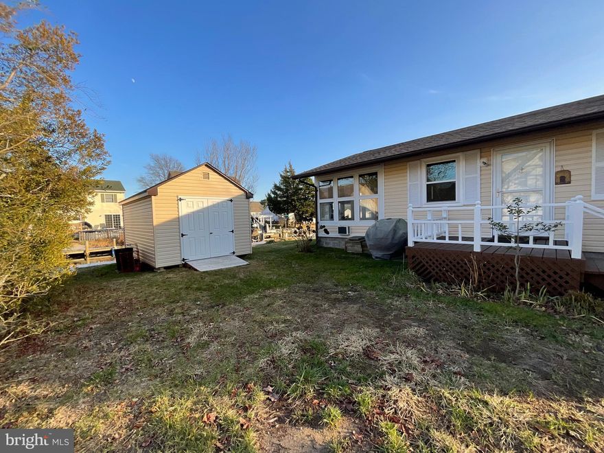 Opportunity Knocks - Looking for a waterfront small home with room for expansion (go up or have home raised) must check with County to confirm.  This 2 bedroom home features, newer windows, roof and vinyl Bulkhead (replaced in 2023).  Bath completely redone making this home ready to enjoy with no extra expenses.   Kitchen appliances replaced, Bryant ductless Heat/AC is a split unit.  Well pump and hot water heater are in the adjoining shed.  This is the perfect starter home for 1 or 2.  Located on a high lot which does not require flood insurance.  The 3 season porch is delightful and the 10x16  shed is on property.  Boat lift is 4,000 lb combined.  Full size washer/dryer stack unit in closet.  Off street parking for 2.  Easy access to the Isle of Wight Bay.  What a fun Summer place!  Don't miss out.