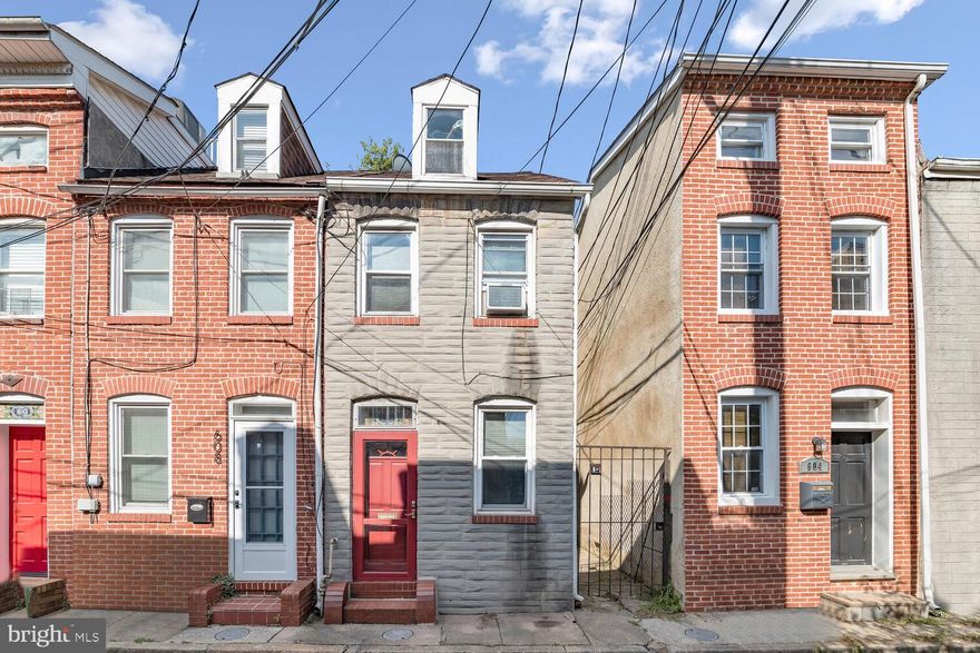 Charming two-bedroom rowhome perfectly situated in the dynamic Historic Fells Point neighborhood. As you enter, a harmonious blend of timeless allure and modern living awaits, showcased by the transom window, rich hardwood floors, and a contemporary neutral color scheme that flows throughout. The living room, adorned with inviting textured brick walls, seamlessly transitions into the dining area, setting the stage for intimate meals. The passageway to the kitchen, adorned with ceramic tile flooring showcases complementary styled appliances plus gas cooking and encourages easy conversation while crafting culinary delights. Step outside onto the private courtyard platform deck and savor open-air dining accompanied by gentle breezes. Venturing to the first upper level reveals the primary bedroom, graced with an exposed brick wall and a revitalizing ceiling fan. The upper-level laundry, full bathroom, and rooftop walkout offer convenience and complete this serene level. Ascend to the second upper-level bedroom, perfect as a private office, enhanced by comfortable carpeting that adds an extra layer of coziness and seclusion. This captivating residence, nestled on a quiet non-through street, is conveniently within walking distance of an array of shops and restaurants. The 137-acre Patterson Park, home to the iconic Patterson Park Pagoda, a boating lake, recreational amenities, and a dedicated dog park, is also nearby. Effortless commuting options are at your disposal, including I-83, Eastern Avenue, public transportation, biking routes, and even the option of a water taxi. Don't hesitate – seize the opportunity to make this enchanting sold-as-is home your own!