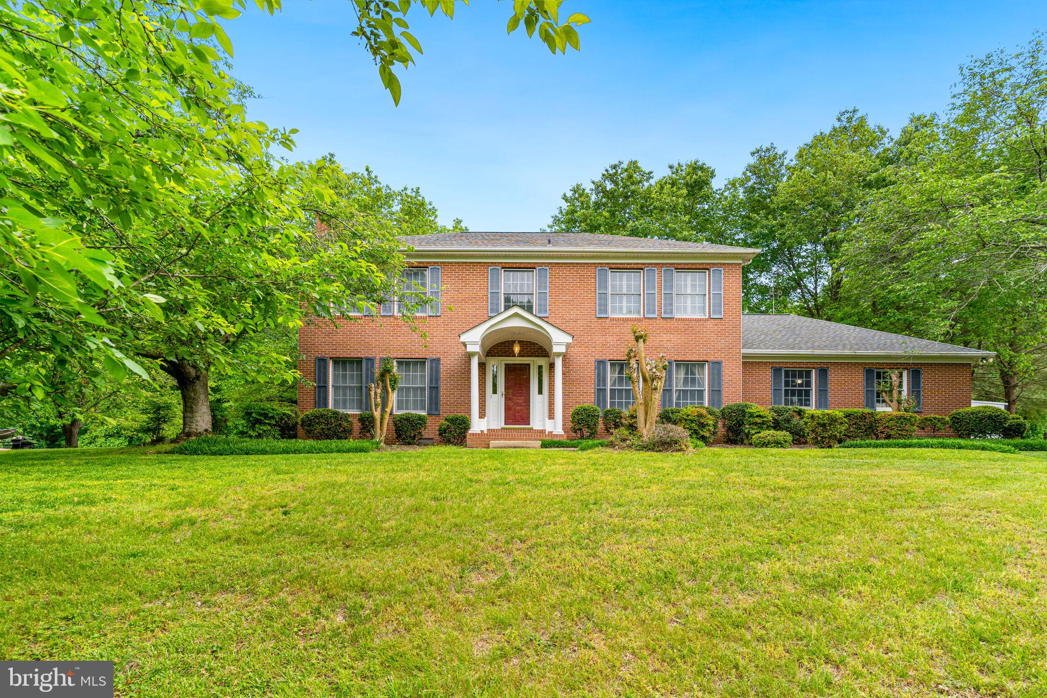 Step into timeless elegance and thoughtful design with this custom-built all-brick colonial, perfectly situated on over an acre of land in the prestigious Twin Lakes community—known for its premier homes and sought-after school district. At the heart of the home is an upgraded kitchen that combines function and style. It features Corian countertops, stainless steel appliances, deep double sink, designer tile backsplash, recessed lighting, and a charming breakfast nook overlooking the wooded backyard. Whether entertaining or enjoying a quiet morning, this space balances comfort and practicality beautifully. Adjacent to the kitchen, the main-level family room showcases gleaming hardwood floors, crown molding, and a high-efficiency sliding glass door that opens to a 10x12 deck—perfect for outdoor dining with views of the serene backyard. Formal living and dining rooms add sophistication with full trim packages, crown molding, chair rail, and hardwood floors. A wood-burning fireplace with an oversized mantle anchors the living room, creating a cozy and inviting atmosphere. The spacious main-level office, set behind double doors, features hardwood flooring and elegant trim, offering a quiet space for work or study. Additional highlights on the main level include a welcoming foyer with hardwood flooring, a hall closet with interior lighting, and a conveniently located half bath. Just off the garage is a well-appointed mudroom complete with upper cabinetry and a laundry sink, providing an ideal transition space. The oversized, side-load two-car garage is a standout feature with a built-in workbench, overhead storage, multiple shelves, and a garage door opener—designed with the hobbyist or extra storage needs in mind. Upstairs, brand-new carpet runs throughout 4 spacious bedrooms and 2 full baths. The owner’s suite is a private haven with a large walk-in closet featuring built-in organizers, an additional cedar closet, and an expansive en suite bath. Enjoy a luxurious spa-like experience with a jetted soaking tub, oversized dual shower with glass door, dual showerheads and 4 body sprays, separate vanities, heated tile floors, and a private water closet with a pocket door. A glass door adds an elegant touch to the suite entrance. The upper level also includes a washer and dryer closet with a front-load dryer and high-efficiency washer, as well as a fully renovated hall bathroom with stylish tile, updated vanity, custom mirrors, and upgraded lighting. Every bedroom offers a ceiling fan, and the upper hallway features continued attention to detail with crown molding and chair rail. ROOF AND BOTh HVAC SYSTEMS HAVE BEEN REPLACED. This beautifully maintained home offers a rare combination of thoughtful upgrades, traditional charm, and peaceful surroundings—ready for you to move in and enjoy.