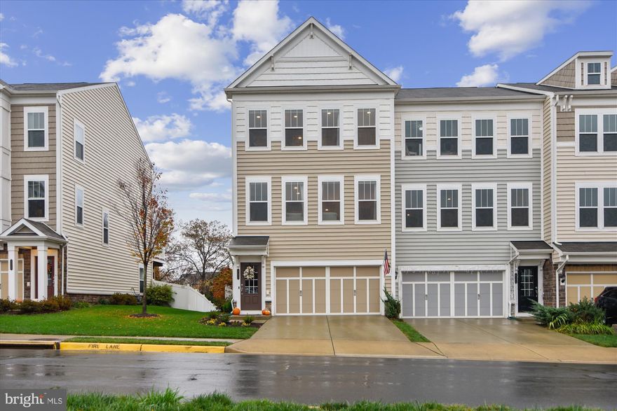 *Open House 4/30 1-3* Stunning end-unit townhome in Brambleton built in 2014. Over 2600 sq ft on 3 levels, this upgraded townhome features a 3-level bump out, fully fenced yard, and 2 decks. The lower level features a 2-car garage with storage, a coat closet, utility room, and a rec room with carpet and soaring ceilings, which walks out to the fenced yard and lower level Trex deck. On the main level, you’ll find beautiful hardwood floors, custom window treatments, open concept floorplan, white shaker cabinets with huge island, granite countertops, recessed lighting, stainless steel appliances, gas cooking, dining room, family room with wall mounted tv, and a flex space perfect for a home office, sitting area, play room, or craft room that leads to a Trex deck overlooking an open common space that will never be built on. Upstairs you’ll find an enormous primary bedroom with 2 walk-in closets, en-suite bath with dual vanities, large shower, and sitting area. Each of the 2 secondary bedrooms has a large closet and access to the hall bath with tub. The full size laundry area is right outside of the bedrooms and across from a generous linen closet. The HOA fee is $224/mo and includes lawn care and maintenance, cable and high speed internet through Verizon. Brambleton is a vibrant community with lots of events, pools, parks, trails, a Town Center with retail shopping, grocery store, library, movie theater and restaurants.  This townhouse is just steps to the Brambleton Corner Clubhouse and Pool.