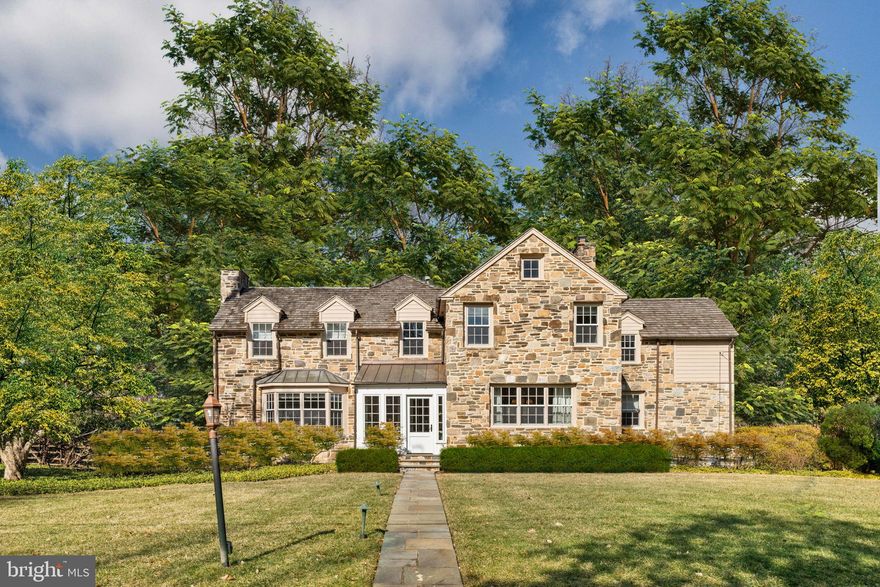 Built in 1951, this refined stone colonial home is situated on a quiet residential cul-de-sac, just a short walk from the Bryn Mawr train station and the vibrant downtown area, known for its selection of restaurants, boutique shopping, and theater. Since its purchase in 2021, the property has undergone a series of thoughtful updates and renovations, enhancing both its functionality and aesthetic appeal while preserving its timeless character.
Wide-plank, lightly stained hardwood floors unify the color palette throughout the first and second floors, creating a harmonious flow. The addition of a south-facing front entry, designed with flagstone floors and wrap-around windows, serves as both an elegant solarium and a functional entry space.
The interior foyer opens to a formal living room with a gas fireplace and a deep bay window, providing a warm and inviting setting. Opposite, the dining room is graced with two exposures of natural light and features smartly styled pocket doors, allowing for separation from the kitchen during formal gatherings.
The kitchen has been meticulously transformed with a focus on both form and function. It features sparkling white cabinetry, stone countertops, and updated polished nickel hardware. A suite of high-end appliances, island seating, and a bright breakfast area make the space ideal for both everyday dining and entertaining. Oversized eastern and southern windows flood the kitchen with natural light, while newly added custom display and storage cabinetry enhance its practicality and elegance.
Wide stairs lead to the dramatic step down  family room, where two full walls of windows provide serene views of the rear gardens, lawn, and courtyard. A gas fireplace serves as a focal point opposite custom shelving. A thoughtfully designed bar area with display shelving, a sink, and a beverage chiller connects the formal living room to the family room and leads to a covered patio. This outdoor space extends to a pool, pergola, grill, and an expansive seating and entertaining area.
The second floor features a generously sized furnishable foyer and three well-appointed family bedrooms, each with an en-suite bath and ample closet space. The newly reconfigured primary suite boasts high ceilings, multiple closets, and a luxurious bath, with views overlooking the pool and gardens. A cohesive color palette of neutral whites, beiges, and grays extends throughout, enhancing the home's turnkey appeal.
The lower level includes a stadium-seated movie theater, installed by the current owners, and a walk-in temperature-controlled wine cellar. A spacious laundry room, extensive storage with built-in closets, a half bath, and access to the rear courtyard and guest area complete this level.
Above the three-car garage, a versatile guest space is currently used as a gym and golf simulator. With a full bath with shower, this area can easily be repurposed as a standalone guest suite, home office, media room, or recreational space.
Positioned on a sought-after "trick-or-treat street" and presented in immaculate, move-in-ready condition, this home is a rare opportunity for those seeking a sophisticated and thoughtfully modernized residence.
No appointments will be available before the scheduled open houses on Friday, Saturday, and Sunday. No exceptions.