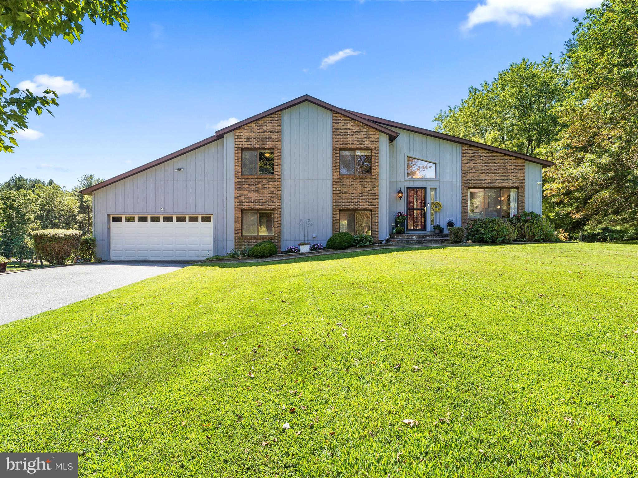 **Check out the video tour!** This open-concept split-level home sits on a beautiful 1.6-acre lot in the Franklin Valley neighborhood. Mature trees provide shade, while newly planted trees along the side yard will grow into a natural privacy screen.
Inside, the living area feels open and inviting with vaulted ceilings, skylights, and elegant tile work welcoming you at the entry. The layout flows seamlessly into the dining room, which opens to a large deck perfect for dining al fresco. The kitchen features white cabinetry, a center island (conveys), stainless steel appliances, and a double oven.
Upstairs, you’ll find three bedrooms with airy vaulted ceilings, a full hall bath, and a half bath attached to the primary bedroom. The lower level offers new flooring, abundant natural light, a cozy fireplace, an additional bedroom and full bath, laundry, garage entry, and walkout access to the rear yard.
Enjoy summer days in the above-ground pool with a liner replaced just last year. Relax or entertain on the deck and keep your tools and seasonal items organized in the shed. The expansive yard provides plenty of space for activities, little ones, pets and more.
A long paved driveway and two-car garage provide ample parking. Located just minutes from shopping, dining, and local conveniences along Reisterstown Road/Main Street. Commuting is easier with quick access to I-795 as well as Routes 30 and and 140. The Reisterstown Sportsplex is just minutes away, with Costco a little over 7 miles, and Trader Joe’s and Target both within 15 miles. Nature lovers will appreciate being just a stone’s throw from the scenic Liberty Reservoir and the surrounding Liberty Watershed area, perfect for hiking, fishing, and outdoor escapes. Buyer to verify school districts.