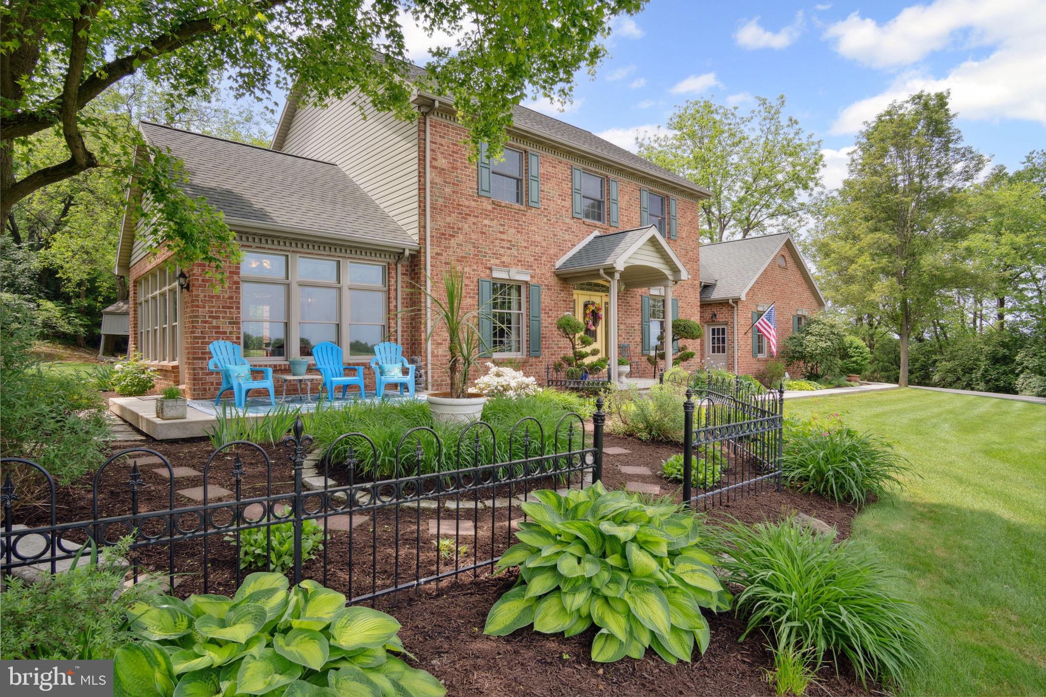 The designers of this elegant custom brick Colonial home blended architectural treasures with modern construction for a one-of-a-kind home with beauty, character, and quality. These captivating architectural pieces were collected throughout Pennsylvania and the Tri-state area, and they were designed into the house upon construction. Many authentic accents were acquired from noteworthy locations such as Philadelphia, Hershey, and Gettysburg. Highlights include striking vintage mantels, noteworthy period lighting, ornate glass doors, and stunning stained-glass windows. Set on a scenic 1.37-acre partially wooded lot with a tranquil garden setting, this home offers 3 bedrooms and 3 full bathrooms across 2,961 total square feet of thoughtfully designed living space. The open-concept floor plan is anchored by soaring 9’6” ceilings, a grand open foyer, and abundant natural light pouring through large windows that frame the peaceful surroundings. Hardwood ash flooring and ceramic tile carry throughout the main level, complementing the rich textures, timeless architectural details, and three fireplaces. The kitchen features custom built solid oak cabinets with an abundance of storage, granite countertops which flow seamlessly into the living and dining areas—perfect for entertaining or everyday living. The light-filled peaceful bedroom suite is spacious and includes both double closets and a generous walk-in closet. A dedicated home office provides a quiet space for work or study, while the lower-level recreation room or movie room offers a cozy retreat. Enjoy relaxing afternoons in a spacious four-season sunroom, surrounded by sparkling stained-glass windows, designed by a local artisan. Experience eight-foot pocket doors, crafted hardwood crown molding with dentals, and custom oak trim moldings milled especially for this home. Appreciate a stunning 130-piece beveled door designed into the interior, repurposed from a Philadelphia mansion. Step outside to enjoy multiple brick patio areas, including a private rear patio that feels like a secluded garden escape, while the front patio offers picturesque landscapes. Additional highlights include a durable brick exterior and natural landscaping which enhance the home’s beautiful curb appeal, with an oversized three-car garage. Perfectly located with convenient access to I-81, this home offers a rare opportunity to own a one-of-a-kind custom-built residence, where every detail has been curated for charm, quality, and timeless appeal.