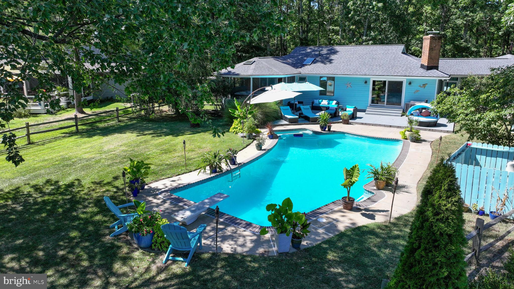 Nestled in the prestigious community of Queen Anne Colony, this tropical, turquoise rancher is perfectly situated on a gorgeous, wooded, 1/2 acre lot, with a 2 car garage and has stunning views of the private, in-ground, gunite pool and the Blue Heron Golf Course, making it the perfect spot to relax and entertain guests. The outdoor space is truly the highlight with a newly resurfaced pool, a stamped concrete patio, a screened-in gazebo with a 4- person, Hot Springs hot tub, a mounted, flat screen TV, a new skylight, a screened-in breezeway that is a perfect spot for a picnic table and even has a large shed to store your pool supplies, The hot tub is even accessible from both the backyard and the primary bedroom, making it the ideal retreat at the end of the day. The backyard is surrounded by a split rail fence (wired) and has a dog run on the side of the house making this home pet friendly. Inside, the home features hardwood flooring in the living room, dining room and kitchen and LVP flooring in the bedrooms. The open layout has a seamless flow for both entertaining and everyday living. From the living room, you can enjoy the view of the pool through the sliding glass door. The fireplace has an insert, providing warmth and ambiance, without the firewood and matches. The gorgeous, gourmet kitchen is equipped with beautiful, custom cabinetry with a built-in wine rack, a stone tile backsplash, granite countertops, a large island and stainless-steel appliances, including a new refrigerator in 2022, a pantry and recessed lighting. The primary bedroom has an ensuite bath with a barn door, a glass shower with contemporary tile, a glass bowl and a new skylight. The hall bath has neutral, gray tile, a double vanity with drawers and a quartz countertop. This sought-after neighborhood also offers water access to the Chesapeake Bay, where residents enjoy kayaking, paddleboarding, and fishing. If you like walking or biking, the trail begins at the entrance of the neighborhood, making it easy to enjoy. The Bay Bridge is just minutes away, making commutes or weekend trips a breeze. This home could be used as an Airbnb for weddings and events in the area. The upgrades include:
New roof and skylights (Jan 2023)
Pool resurfaced with new coping/tile (May 2023)
Pool filter (2023) and pool pump (2021)
Water softener (2023)
Sump pump (2020)
Stamped concrete patio around the pool and out front
Sliding door to pool (2021)
Well pump replaced (2023)
This home offers more than just a place to live -- it is a lifestyle, surrounded by natural beauty,
recreation, and comfort. Call or email for more information or to schedule a showing.