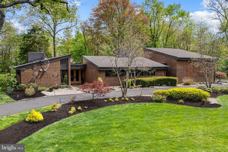 A Usonian-inspired Mid-Century Modern retreat set on a private 1.27-acre tree-lined lot along prestigious Cathcart Road in Blue Bell. 

Defined by its clean architectural lines, expansive walls of glass, and seamless indoor-outdoor integration, this all-brick residence embodies the essence of iconic Mid-Century design, thoughtfully updated to deliver both character and turnkey comfort. 

A restored terra cotta entry and exposed brick foyer introduce the home’s distinctive aesthetic, drawing you toward a stunning central courtyard framed by sliding glass doors and clerestory windows. This striking design creates a natural connection between interior spaces and the surrounding landscape, ideal for both everyday living and elevated entertainment. 

The main living wing features a dramatic open-concept layout with soaring vaulted ceilings, anchored by a double-sided gas fireplace and custom built-ins. The chef’s kitchen has been fully reimagined with custom soft-close cabinetry, quartz countertops, designer lighting, and a premium Dacor appliance suite creating a true entertaining showplace.

A private office, powder room, and expansive family room - complete with a wood-burning fireplace and vaulted ceilings—provide additional flexibility and comfort within the home. 

The private bedroom wing offers a tranquil retreat, with all rooms positioned along the opposite side of the courtyard for optimal separation. The primary suite features a custom walk-in closet and a spa-inspired bath with a freestanding soaking tub and Kohler electrostatic shower system. Three additional bedrooms—one ensuite—are complemented by a beautifully updated hall bath, each space reflecting a seamless blend of modern refinement and original architectural character. 

A well-appointed laundry/mudroom offers both functionality and style, with custom cabinetry, quartz surfaces, and direct outdoor access. 

Enhancing the home’s versatility, a private-entry in-law or guest suite above the attached oversized two-car garage includes a full bath. Natural gas and water lines are in place for a kitchenette—ideal for multigenerational living, extended stays or a dedicated home office. 
The oversized garage is finished with a professionally installed Aspartic coated floor, upgraded lighting and abundant overhead storage. 

Surrounded by mature trees and professionally landscaped grounds, this exceptional property offers both privacy and convenience, with easy access to major commuter routes and top-rated schools. 

For the discerning buyer seeking architectural significance paired with modern luxury—this is  truly a one-of-a-kind offering!