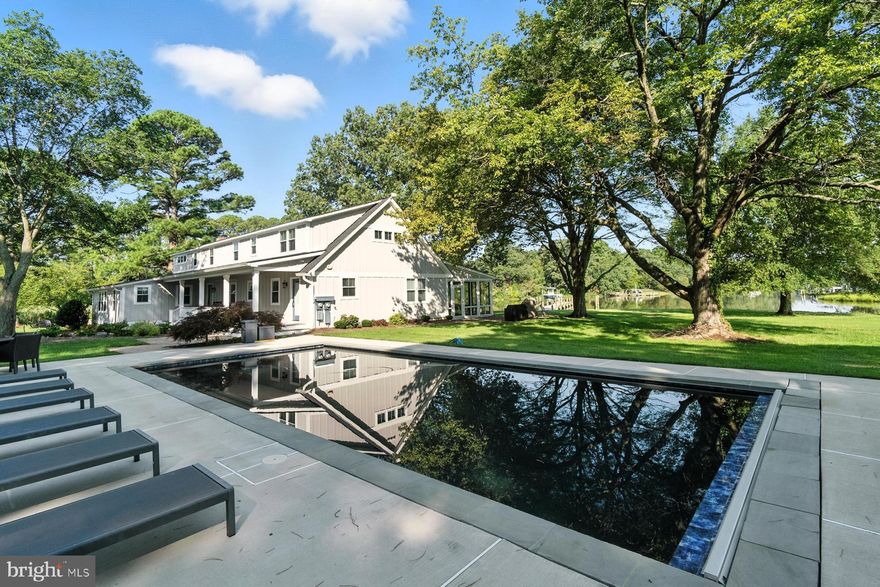 Welcome to ‘Drake’s Landing’! Beautifully sited on 20 picturesque acres on the shores of Irish Creek, this 4,602 sq. ft .completely renovated (2021) waterfront estate offers the perfect blend of casual elegance and thoughtful design. The main level welcomes with expansive water views and features a guest bedroom with ensuite bath, a cozy family room (or den/office), and a gracious living room anchored by a large brick hearth and woodburning fireplace. The gourmet kitchen is the center of the home - outfitted with upgraded appliances, a center island with breakfast bar, and additional dining space. Adjacent is a second kitchen - ideal for effortless indoor/outdoor entertaining. A formal dining room and large waterside sunroom complete the main living spaces. Upstairs, two spacious primary suites anchor each end of the home, offering privacy and comfort, with two additional guest bedrooms (one with ensuite bath) and a hall bath in between. Step outside to enjoy westerly water views from the elevated deck, or gather on the enclosed screened porch, perfect for crab feasts and sunset dining. Outdoor amenities include a charming 2BR/1.5BA guest cottage (540 sq. ft.), a new dock with two slips, stunning waterside pool,  waterside firepit, and barrel sauna. A 3-bay equipment garage is connected to an enclosed game room and workshop - creating a complete retreat for relaxation, recreation, and unforgettable waterfront living. The property with its acreage is also great for hunting. This is Eastern Shore living at its best – spacious, serene, and set up for year-round enjoyment. *Furnishings may be available for sale.