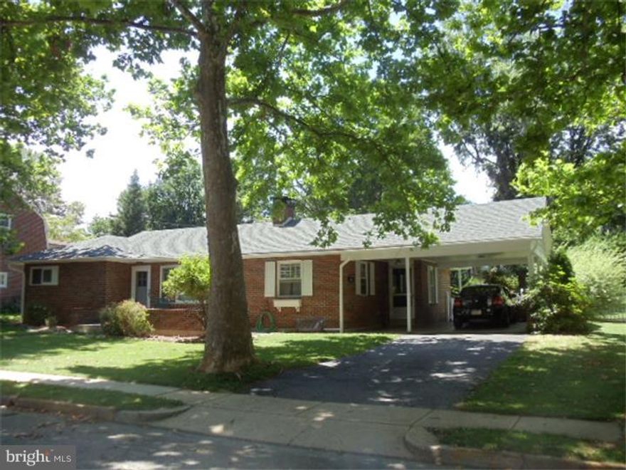 NEW PRICE! BRAND NEW roof June 2014! Beautiful brick Ranch with slate porch surrounded by mature landscaping that blooms Spring to Fall sitting on a double lot that is fully fenced in with vinyl fencing on a pretty tree lined street. Inside you will find plenty of character with hardwood floors, arched doorways and a wood burning fireplace in the living room with sliders out to a private and peaceful large covered patio and back yard.  An eye catching  open staircase takes you down stairs to the family room with slate floors.  Two full baths, one with a sky light.  Central air to keep you cool in the summer.  Plenty of storage with storage room and attic above carport. Reading inspection already done for you and Seller offering a 1 yr Home Warranty with acceptable agreement of sale.