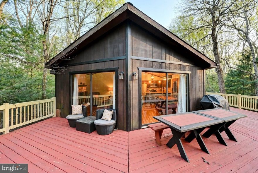 Turnkey STR opportunity or vacation home in Towamensing Trails! Located on a quiet, low-traffic street, this fully furnished raised ranch Chalet 4BR/2BA home sits on an oversized parcel with the included adjacent lot on Dryden Drive, offering over 1 acre of land for added privacy and future potential. Designed with short-term rental use in mind, the home offers flexible living space across two levels. The upper level features a full kitchen, coffee bar, 3 bedrooms, 1 full bath, and a cozy wood-burning fireplace. The lower level is set up as a recreation/game area along with an additional bedroom and a second full bath, ideal for maximizing enjoyment. Attached 1-car garage for additional storage or to park your golf cart! Recent updates include a deck brought up to township code. Property is being sold fully furnished, making for an easy, immediate STR launch or seamless transition for a second home buyer. Prime location just minutes to I-80 and the PA Turnpike, with close proximity to Jim Thorpe, Lake Harmony, and area ski resorts. Towamensing Trails amenities include a 190-acre lake with beach access, outdoor pool, tennis courts, playground, and private restaurant. Property is served by a 3-bedroom septic system. Buyer always must perform due diligence regarding STR use with township and HOA.