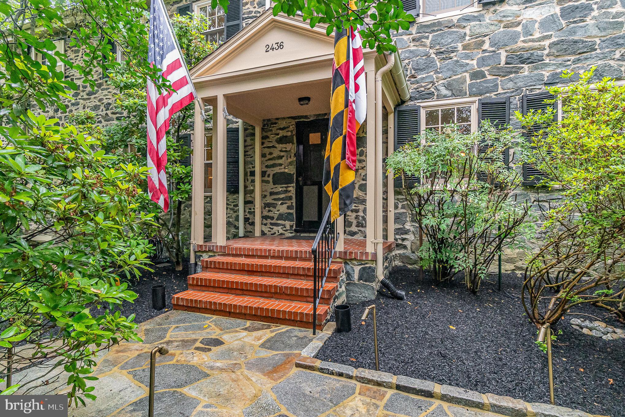Welcome to historic Dickeyville, a designated city, state, and federal landmark district and one of Baltimore’s most charming and distinctive neighborhoods. Nestled along the Gwynns Falls and adjacent to Leakin Park, this peaceful and tight-knit village offers a bucolic, residential atmosphere surrounded by natural beauty, all within close proximity to Interstates 70 and 695. Downtown Baltimore and BWI Airport are just 20 minutes away, and Catonsville is an easy 10-minute drive.
Dickeyville traces its origins to the 1750s as a textile mill village and was named after William J. Dickey, the last mill owner. Many of the existing homes were built in the early to mid-19th century, and in 1934, the entire village was sold to a developer who thoughtfully renovated the historic structures and built new homes in keeping with the original architectural style. The result is a beautifully preserved and cohesive community that feels like a step back in time—yet remains easily accessible to modern conveniences.
Built circa 1840, this grand stone home is one of the largest in the village, offering over 3,300 square feet of fully renovated and tastefully updated living space. Set atop a landscaped knoll in the heart of Dickeyville, the home provides both privacy and a central location, just a short walk from the Falls. The main entrance opens to a gracious center-hall foyer, leading to a spacious living room with a fireplace, built-in cabinetry, and large windows that overlook the picturesque front yard. Toward the back of the home, the formal dining room features a built-in china closet. A renovated butler’s pantry features generous storage and cabinetry. The adjacent kitchen has been completely renovated while maintaining the home’s historic charm. It features a large center island, high-end appliances, extensive storage, marble counters and backsplash, and a wall of windows offering serene views of the expansive, landscaped backyard. From the butler’s pantry, there is access to a two-car garage with an automatic door opener. A roomy den, which can serve as a first-floor bedroom or office, and a powder room complete the main level.
A main staircase from the foyer and a secondary staircase from the butler’s pantry both lead to the second floor. At the top of the main stairs is a sunlit conservatory with French doors that open to a private balcony overlooking the rear garden. The second level also features a large family room with a wood-burning fireplace and 75-inch flat-screen TV, a dedicated home office with custom built-in cabinetry, and a well-equipped laundry room with a washer/dryer, utility sink, ample cabinetry and counterspace. The bedroom wing includes a fully renovated hall bath and a comfortable secondary bedroom, along with a spacious primary suite. The primary bedroom offers two closets, a 50-inch flat-screen TV, and a luxurious ensuite bath with an oversized marble shower. Both bathrooms on this level are finished with marble flooring, and the primary bath has full-height marble tile walls.
On the third floor, you’ll find two additional generously sized bedrooms and unfinished attic storage space. The home also includes central air conditioning, Marvin replacement windows throughout (except for the balcony rooms), a slate roof, and a security system, blending modern comfort with timeless craftsmanship.
Rarely do homes of this size and caliber become available in Dickeyville. This is a truly exceptional opportunity to own one of the most distinguished and beautifully updated residences in one of Baltimore’s most treasured historic communities. A separate list of room features and dimensions is available upon request.