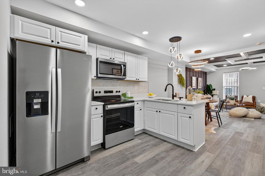 Step into modern sophistication with this stunning, fully renovated home where contemporary design meets cozy comfort. This property has been meticulously curated with high-end finishes and bold architectural details that set it apart from the rest. The open-concept main floor is anchored by a gourmet kitchen that is as functional as it is stylish.  Crisp white cabinetry with sleek black hardware. Elegant white quartz countertops and a classic herringbone tile backsplash. A premium stainless steel appliance package, including a deep undermount sink with a modern matte black faucet. A versatile breakfast bar perfect for morning coffee or casual entertaining.
The living area is a true showstopper, boasting a dramatic black coffered ceiling accented by crisp white crown molding and recessed lighting. A custom slate-colored accent wall with vertical slat detailing adds texture and depth, creating the perfect backdrop for the spacious lounge area. Unique, artistic lighting fixtures serve as functional art throughout the home, from the sculptural pendant over the kitchen to the halo rings in the living room. The home is filled with designer touches, including a pop of color with a charming salmon-toned door and high-contrast black banisters that guide you upstairs. Integrated microwave, smooth-top range, and spacious side-by-side refrigerator. Large windows allow for an abundance of natural light to fill the living spaces.
This home is perfect for those who appreciate bold design and a seamless flow for entertaining. Don't miss the chance to make this masterpiece your own!