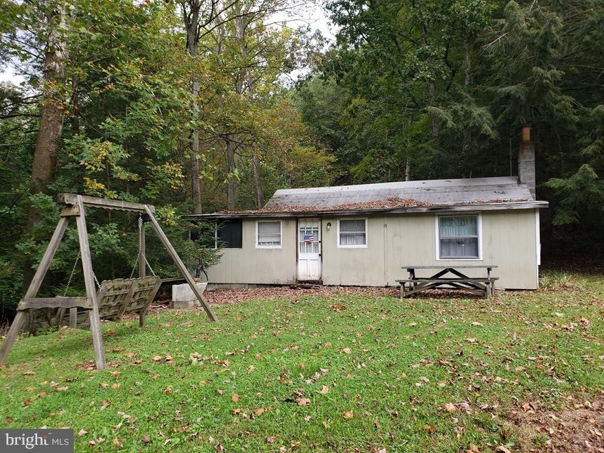 Check out this sweet cabin on 2.3 partially wooded acres nestled in it's own private little valley along the clean, clear and serene Laurel Run Creek!  Kitchen, dining area, living room, 2 bedrooms and  a room that could be a bathroom if you choose to install a septic system. Otherwise, you will need to install an incinerating toilet, composting toilet, outhouse, or a port a potty.   State Game Lands nearby. Easy access from public road yet private. 100 Amp electric and well with a hand pump on property, Laurel Run is a stocked trout stream.  Call to see it today!