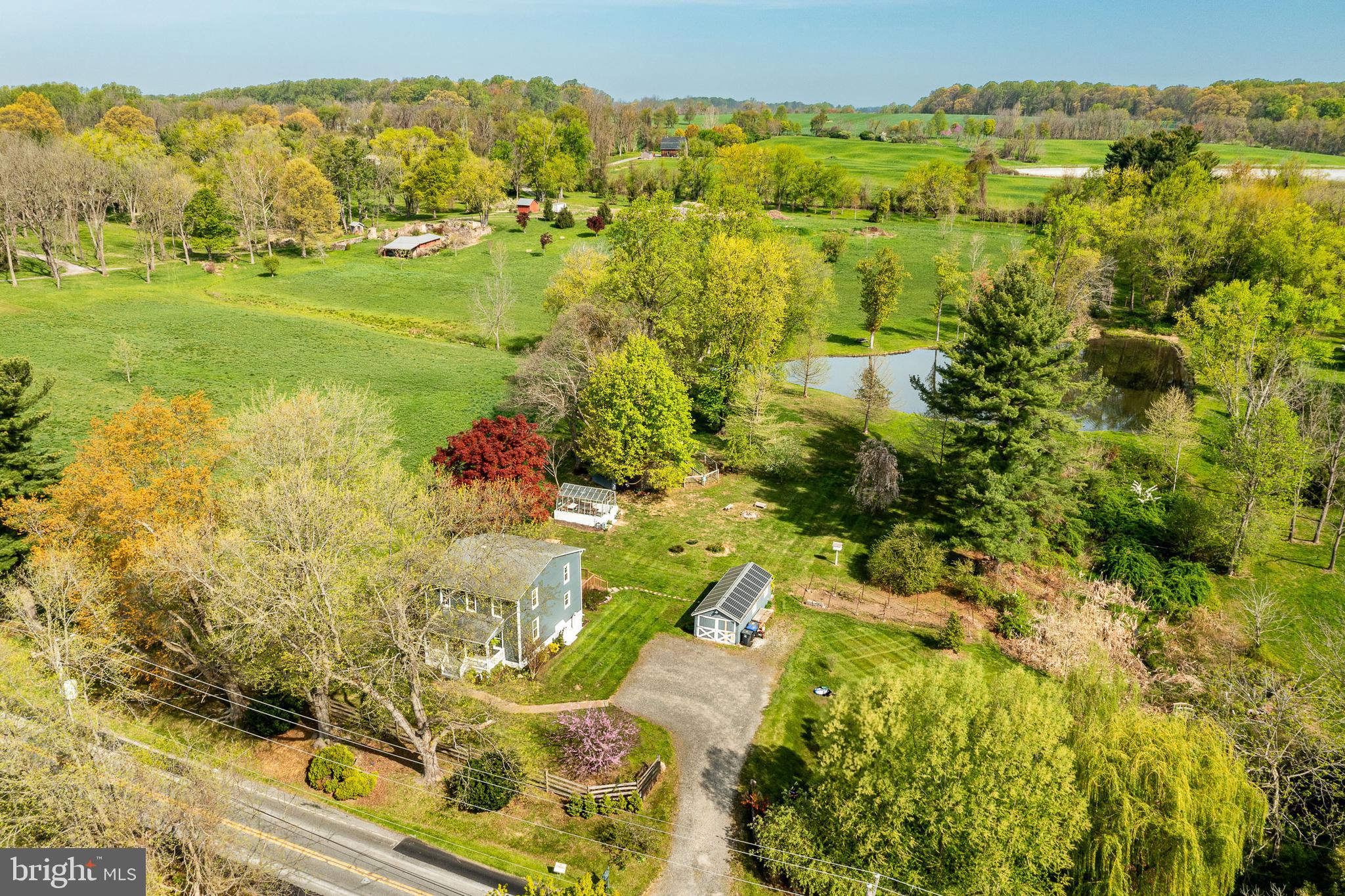 Come visit this private countryside retreat located in the heart of horse country in Chester County and in the award-winning Unionville-Chadds Ford School District. If you enjoy being surrounded by nature, but don’t want a lot of maintenance, this is the perfect property for you. This parcel is one acre, yet gives you the feeling of living on your own private wildlife preserve. This is a rare opportunity to live near community life but be surrounded by hundreds of acres of preserved open space with unsurpassed views and direct access to township-maintained walking and riding trails. Take a short stroll on a beautiful trail to watch a polo match or relax on your spacious back deck and enjoy private views of the neighboring pond and stunning sunsets. The abutting township land also features a large pond, full of bass, catfish, and sunnies. For avid birders there are geese, ducks, bald eagles, herons, hawks and a variety of songbirds that visit the back yard.
This historic three bedroom, two and a half bath home was completely renovated in 2013 but retains the character of a 100+ year old farmhouse. Original beams were exposed in the kitchen and many original solid wood doors remain. The original baseboard trim was kept with additional boards milled to match. The home is very energy efficient; with geothermal, solar, spray foam insulation, energy star appliances, and large efficient windows that let in plenty of sunlight. Brand new no -maintenance siding and window trim were just installed. The home has hardwood floors throughout. The attic and basement offer ample room for storage. If you enjoy cooking and baking, the kitchen includes a five-burner gas stove and oven, with two additional propane connections that could be used for other gas appliances. Take in the views of the pond and greenhouse when you sit down for meals or enjoy your morning coffee. You can also relax in a rocking chair on the charming front porch and watch the horses graze in the neighboring pasture.
There is a detached garage and workshop on the property. This offers plenty of room to store your tools and equipment and work on projects. It has lights and electrical throughout, as well as a connection on the outside to charge an RV.
This property has everything you need for your own small backyard farm. For the avid gardener, there is a stunning vintage greenhouse that has been lovingly restored. It offers the perfect space for some plant therapy and offers a warm sunny escape in the cooler months to relax in the sunshine. Start your seeds here and then make use of the abundant yard space and fertile soil to grow fresh herbs and vegetables. There are mature grape vines and various fruit trees on the property, including a persimmon tree that fruits in the fall, when there is also an abundant harvest of chestnuts. There is a small paddock with no-climb fencing and a large run-in shed; perfect for small farm animals or to store equipment. Horses were kept here in the past. This property is near numerous equestrian facilities. The Cheshire Fox Hunt occasionally rides by as well. Many specimen trees have been planted on the property, offering a burst of color in the spring and fall. The small stream on the property is lined by picturesque weeping willow trees and cattails.
The property is just a short drive to Kennett Square, Longwood Gardens, and numerous parks with miles of trails for hiking. Wilmington and the Philadelphia International Airport are both less than 35 minutes away.