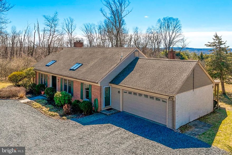 Nestled on just over four private acres just minutes from central Doylestown is this classic Luther Nash expanded ranch home. Here you will find the renowned Nash craftsmanship paired with an expansive, flexible layout, and featuring lovely views and sun-filled rooms. The main level connects a large open kitchen, with a center island, ample cupboards and lots of counter space, to a comfortable and inviting family room with gas burning fireplace framed by built-ins. Just beyond is a large sun room and dining area with a wall of windows and access to a three season room, and to the deck with perennial gardens and fenced lawn area. The gracious formal living room, with another fireplace, two walls of built-ins and sliding doors to the three season room, adds a separate space for entertaining or quiet evenings. Also on the main floor is the large primary bedroom with en-suite bath and dressing area, and with two dedicated offices allowing for true work-from-home separation. A gracious entry foyer, a large, tiled informal entry with laundry space, and a second full bath complete the main floor. Upstairs are two bedrooms, a full bath and a walk-in storage room . Downstairs, the large unfinished basement offers excellent storage, and outside access. The property includes an attached, oversized two-car garage, and two easily accessible garden sheds. This peaceful and secluded rural retreat is a 10 minute drive from the many shops, restaurants, and recreational and cultural offerings in vibrant  Doylestown. Central Bucks School District.
