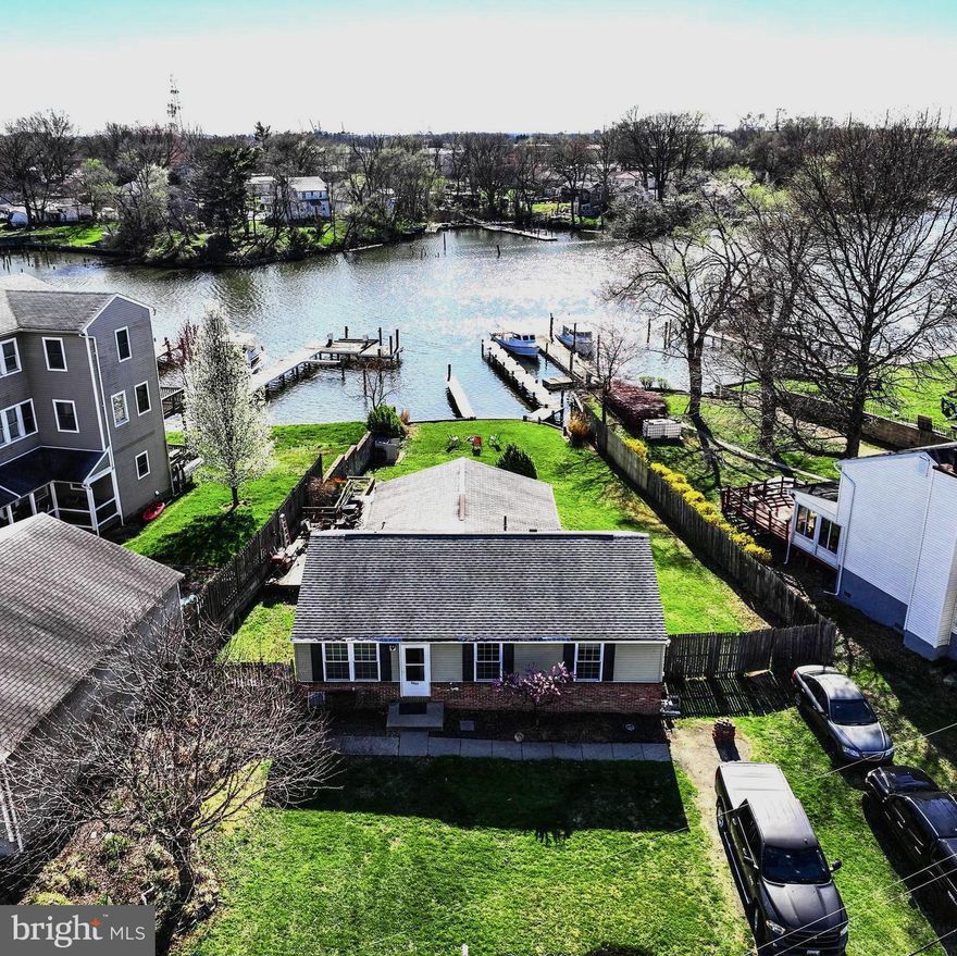 Welcome to 8027 Shore Road! Wonderful waterfront living, at its finest. This charming home boasts 3 bedrooms and 1 bathroom, with hardwood flooring throughout. The spacious primary bedroom is perfect for relaxation, and all bedrooms are equipped with ceiling fans for comfort. The kitchen features stainless steel appliances and a convenient built-in desk area. The great room is flooded with natural light and offers stunning water views, with easy access to the rear yard. There is a bonus room underneath the Great Room to the side of the house that can be turned into an extra living space. The large deck is perfect for entertaining guests or simply enjoying the serene surroundings. You'll also appreciate the convenience of a driveway, providing ample parking space. Located on Lynch Cove, this home offers a peaceful waterfront setting that's sure to impress. Take the boat out, drop the canoe in the water, or paddle board out to the cove, right from your back yard. The water depth is on average 6ft and can go up to 13ft, right under both of your piers. The larger pier is 90ft while the other is 48ft. There is also a tool shop to the side of the home, its attached/underneath, and has heating/cooling and power! Don't miss your opportunity to experience the best of waterfront living at a remarkable price. - schedule a showing today!