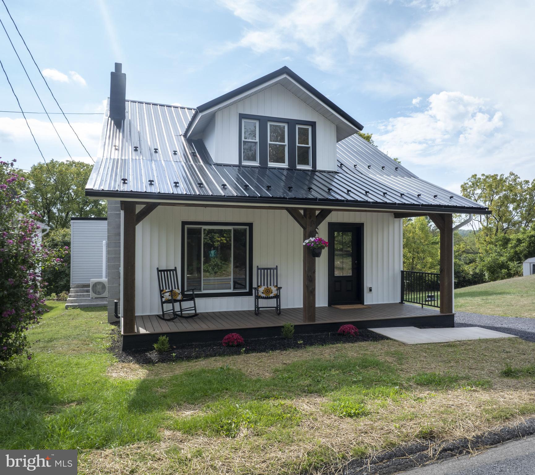 This adorable, charming Cape Cod has been completely remodeled and is move-in ready. From the comfortable covered porch to the back deck and everything in between, this beauty has it all. Relax on the beautiful new front porch and enjoy watching the bicycles ride by.
Step into the open living room featuring an electric fireplace with a wood mantle. The kitchen includes a large, functional island with a sink, electric outlets, bar stool seating, and granite countertops, opening to the dining room. The first-floor owner’s suite offers a spacious bathroom with a glass-panel shower and access to the deck for enjoying fresh air. Upstairs, you’ll find three additional bedrooms. From the contractor’s handmade barn doors to the many special touches throughout, this home is truly worth seeing. Stop by on Sunday, September 7, 2025, from 2:30 to 3:30.