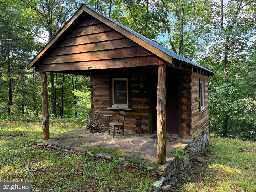 Tucked Beneath the Oaks Along the North River – A Rare Ice Mountain Retreat. This property offers something you rarely find—direct riverfront access, total privacy, and a ready-made escape from the daily grind. Just an hour from I-81 and two hours from the D.C. metro area, this 5.02-acre wooded hideaway feels worlds away. With 350 feet of private frontage on the North River, it delivers one of the most scenic and secluded river settings in the region. Whether you're fishing, launching a kayak, or simply soaking in the sound of water rushing over rocks, the peace you’ll find here is hard to match. The lot is long and uniquely shaped, with varied terrain—including some steep sections—that may require creativity when planning future use or improvements. But the reward is significant: not only exceptional river access and turnkey weekend usability, but also a spectacular potential build site. One particular spot on the property offers a stunning panoramic view across the river to open farmland—a rare combination of elevation, beauty, and buildability. It’s a prime location for anyone considering future expansion or a permanent home in the woods. Privacy is abundant here. At the heart of the property sits a 168-square-foot true log tiny cabin—wired for electricity and full of rustic charm. It’s simple, cozy, and perfect for overnight stays, weekend escapes, or as a basecamp for outdoor adventures. While there is no well or septic system, it’s well-suited for self-contained stays or future development using alternative systems. Ice Mountain is a well-maintained, gated community with protective covenants that preserve the natural beauty and peaceful character of the area. The gravel roads are easily accessible, and the overall atmosphere is one of quiet retreat and connection with nature. If you're looking for a private riverfront property that offers immediate enjoyment and future potential, this slice of Ice Mountain deserves your attention. With rare frontage on the North River, panoramic build potential, and existing improvements in place, this is a unique opportunity to invest in one of the most tranquil corners of West Virginia.