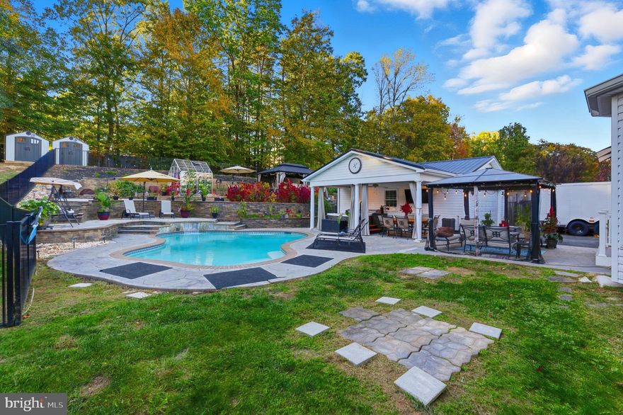 *VA ASSUMABLE LOAN - Your opportunity to purchase with a 2.5% interest rate.* Welcome home to your private oasis in Woodbridge! This stunning three-level residence offers the perfect blend of elegant interiors and an extraordinary backyard retreat that will be the envy of everyone you know. Step inside to discover freshly painted interiors with luxury vinyl plank flooring flowing seamlessly throughout the main level, creating a sophisticated and cohesive look. The bright and spacious living room welcomes you with natural light, while the formal dining room showcases elegant columns and classic chair rail molding, perfect for hosting dinner parties or family celebrations. The kitchen delights with rich wooden cabinetry, stainless steel appliances including a double wall oven, a peninsula bar, and a sun-filled breakfast nook for casual dining. Relax in the cozy family room featuring a fireplace flanked by windows framing your peaceful view. Upstairs, plush carpeting leads to a luxurious primary suite with striking vaulted ceilings and a stunning en suite bathroom, plus three additional generously sized bedrooms sharing a beautifully updated full bathroom. Downstairs, the expansive lower level offers a versatile recreation room to suit your individual needs, plus plenty of storage space. The backyard is where this home truly shines as your personal paradise, featuring an in-ground pool with jacuzzi hot tub, professionally terraced stone landscaping with multiple entertaining areas including covered pavilions with lighting, a charming greenhouse for the gardening enthusiast, and expansive paver patios perfect for hosting gatherings. Additional highlights include a long driveway, attached two-car garage, and a detached two-car garage providing abundant parking and storage. The basement was renovated in 2024, the solar panels were installed in 2022 with the roof being replaced in 2020. New siding 2023, windows replaced in 2022, the kitchen was remodeled in 2023, the primary and guest bath in 2024. New garage doors in 2024 and the flooring was replaced in 2024.  HVAC and furnace were 2023. Located just minutes to Harris Teeter, Giant, Stonebridge at Potomac Town Center, Potomac Mills, historic Occoquan, Quantico, and Prince William Forest Park, with quick access to Dale Boulevard, Prince William Parkway, I-95, and Route 1 for effortless commuting. Schedule a private tour today and start the new year in your new home!