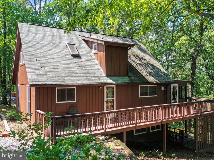 Nestled within the tranquil enclave of Gerrardstown's Deerwood neighborhood, this exquisite three-level cabin offers an idyllic escape into nature's embrace. Revel in the serene vistas and the soothing ambiance that this charming community exudes. Upon entry, you are welcomed into a resplendent great room, where soaring cathedral ceilings and a profusion of expansive windows invite an abundance of natural light, creating an atmosphere of openness and warmth.

The main level boasts a generous 30x10 screened-in porch, seamlessly extending to an additional deck—perfect for enjoying covered alfresco gatherings with loved ones, rain or shine. Ascend to the loft, where the primary bedroom awaits—an expansive sanctuary featuring a private en-suite bathroom, providing a personal haven of relaxation.

Descend to the lower level to discover a cozy family room that flows effortlessly onto the lower deck, offering yet another vantage point to savor the captivating views. This level also presents versatile space, ideal for pursuing creative hobbies, crafting, or establishing a lively game room. A spacious laundry room with ample storage completes this level, ensuring all practical needs are met with ease.

This exceptional property is a harmonious blend of comfort and nature, presenting a unique opportunity to experience the beauty of its surroundings. Seize this rare opportunity before it's gone!