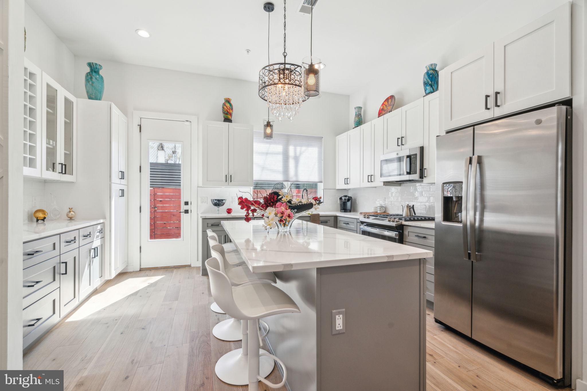 Step into this stunning 17' wide home in Norris Square, featuring light wood floors and an open-concept main level. Oversized front windows fill the living room with sunlight, while a gas fireplace with a tile surround adds both warmth and sophistication.
The main living area flows seamlessly into the chef’s kitchen, outfitted with Carrara quartz countertops, a spacious island with seating, two-tone shaker cabinetry, and stainless steel appliances. Custom built-ins at the rear of the kitchen offer convenience and style, while pantry pull out drawers add additional storage. Step outside to the private rear patio, enclosed by a tall fence—ideal for grilling, relaxing, or letting pets enjoy the green patch.
The second floor is dedicated to the primary suite. The spacious bedroom includes an expansive walk-in closet and large windows that let in abundant natural light. The luxurious en suite bath features a double vanity, linen closet, soaking tub, and an oversized shower with built-in bench.
The third floor features two additional sunlit bedrooms and a full hallway bathroom tucked behind a door for added privacy when entertaining. You'll also find the laundry area here, tucked away on the upper level for ease. Just off the stairway, a sleek wet bar sets the stage for easy rooftop entertaining. The expansive roof deck offers the perfect setting to relax or gather with friends— with outdoor speakers already in place. The house has surround sound wired throughout, ready for speakers to be installed.
The finished basement offers additional living or entertaining space, along with a full bathroom and tub-shower combo.
This block is unique—the residents have a group chat and they have block parties, leading to a community-oriented vibe with neighbors that watch out for each other! Located near Norris Square Park, local restaurants, and one block away from the subway station, this home offers the best of modern living in a vibrant neighborhood. Schedule your tour today!