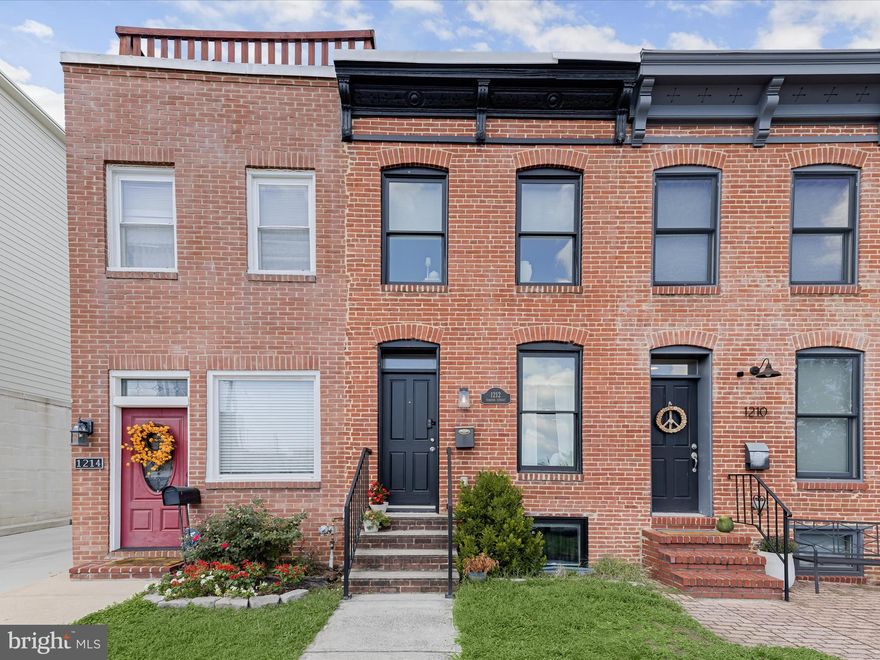 Introducing this beautifully updated rowhome in Locust Point, offering three bedrooms and three full bathrooms across three thoughtfully designed levels. A private parking pad, ample street parking, and a rooftop deck with 360-degree city views elevate everyday living. Inside, a neutral color palette, recessed lighting, and engineered wood flooring create a warm and inviting atmosphere throughout. Crown molding and an exposed brick accent wall highlight the front living room, while the open-concept layout seamlessly connects the dining area and kitchen. Featuring stainless steel appliances, granite countertops, shaker-style soft-close cabinetry, and a breakfast bar with pendant lighting, the kitchen is both stylish and functional. Upstairs, the primary bedroom suite has direct access to the rooftop deck along with a luxurious private bathroom boasting a frameless walk-in shower with bench seating and a dual sink vanity. A second bedroom and another full bathroom complete this level. The finished lower level extends the living space with a third bedroom, an additional full bathroom, and a utility room with laundry. Enjoy the best of city living located in the vibrant Locust Point neighborhood with local parks, shops, dining, entertainment options and so much more. Additionally, there are three years left on a CHAP credit.