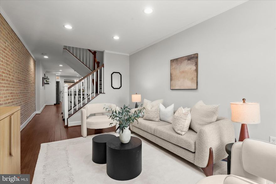 Introducing this beautifully updated CHAP rowhome in Locust Point, offering three bedrooms and three full bathrooms across three thoughtfully designed levels. A private parking pad, ample street parking, and a rooftop deck with 360-degree city views elevate everyday living. Inside, a neutral palette, recessed lighting, and engineered wood flooring create a warm and inviting atmosphere throughout. Crown molding and an exposed brick accent wall frame the front living room, while the open-concept layout seamlessly connects the dining area and kitchen. Featuring stainless steel appliances, granite countertops, shaker-style soft-close cabinetry, and a breakfast bar with pendant lighting, the kitchen is both stylish and functional. Upstairs, the primary suite offers direct rooftop access and a luxurious private bath with a frameless walk-in shower with bench seating and a dual-sink vanity. A second bedroom and full bathroom complete this level. The finished lower level extends the living space with a third bedroom, an additional full bathroom, and a utility room with laundry. Enjoy the best of city living in vibrant Locust Point, close to local parks, shops, dining, entertainment, and more. Approximately three years remain on the CHAP credit (buyer to verify). Some images have been virtually staged.