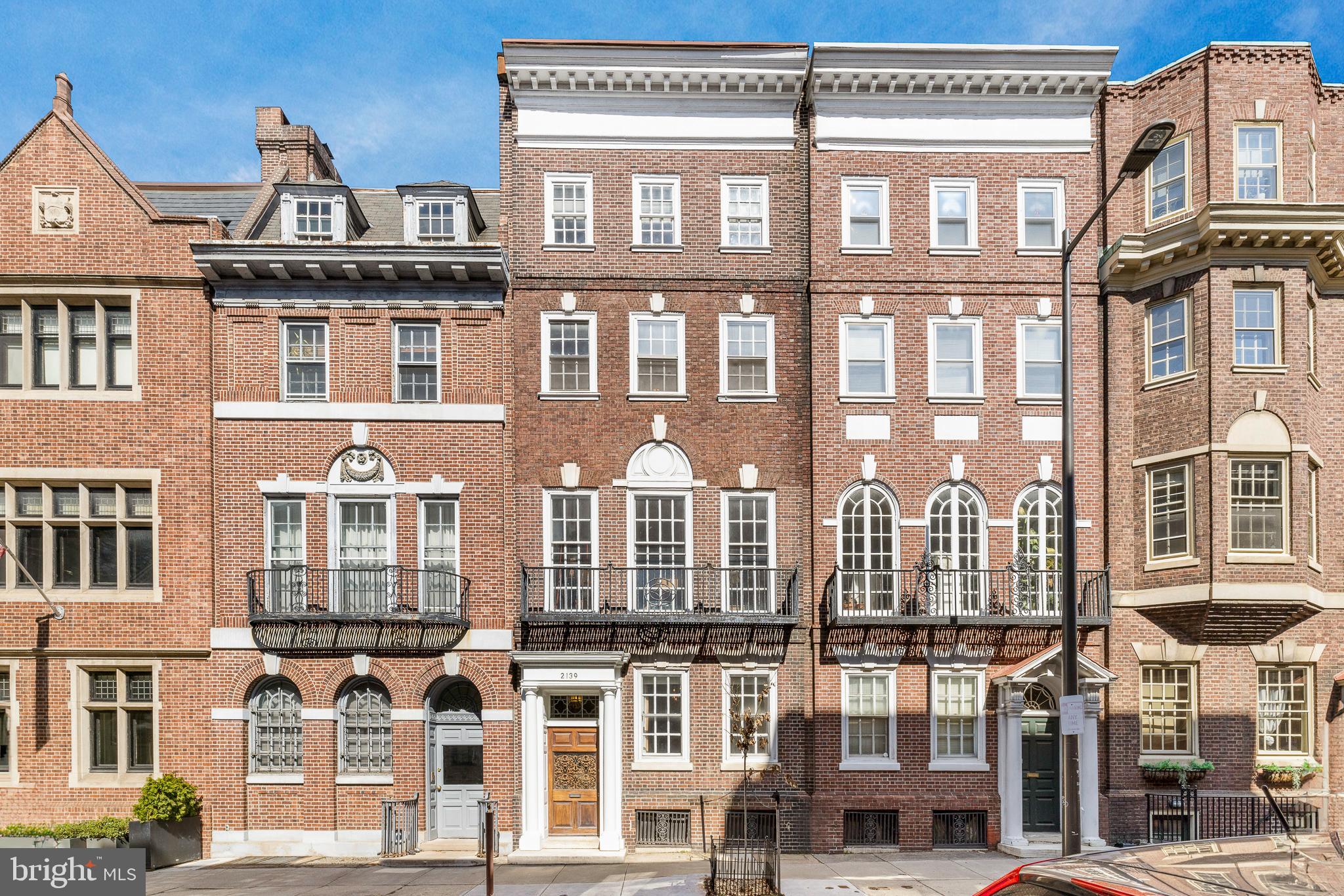 Step into a piece of Philadelphia architectural history at 2139 Locust Street. This grand townhome sits 20 ft in width and was designed by famed Philadelphia architect Charles Burton Keen in 1905 and retains much of its original grandeur uncompromised by the modern upgrades throughout. Spanning over 5200 SF across 4 levels, this home includes 5 bedrooms, 3 full bathrooms, and 1 powder room creating a very flexible floorplan and comfortable rooms. Enter through a large vestibule and into the parlor where you'll first get a glimpse of the striking original staircase of the home. The kitchen is just past the parlor and was thoughtfully designed for cooking and entertaining. Featuring custom cabinetry plus a pantry, built-in refrigerator & freezer, stainless gas range, 2nd oven, 2 sinks, and beautiful stone counters with a drainboard. The kitchen is open to the spacious living room which is anchored by a stately wood-burning fireplace. The formal dining room is in the front of the home and features another of the home's 3 original fireplaces. Also on this level is a conveniently located powder room. The second level begins with a handsome library with oversized south-facing windows, built-in bookshelves, and a fireplace. The Primary suite is also on the 2nd level with a large bedroom, custom-outfitted dressing room, and en-suite bathroom with 2 marble vanities plus a walk-in shower with seamless glass enclosure. The laundry room completes the 2nd floor. The 3rd floor features 3 bedrooms and a roomy hall bathroom with classic finishes and includes a pedestal sink and shower with glass sliders. The 4th level of this home continues with 3 additional bedrooms (one currently used as a home gym), a hall bathroom with marble tile, large vanity and clawfoot tub, plus a kitchenette. This home also has a large basement with multiple rooms and high ceilings with an incredible opportunity to be refinished into a bonus room while still allowing ample space for storage. This Rittenhouse /Fitler location is just blocks from both Rittenhouse Sq Park, Fitler Sq Park, and the Schuylkill River Park and is surrounded by some of the best restaurants, cafes, and retail in the city. Easy commute to Penn, CHOP, Drexel, and 30th Street Station. Located in Greenfield School Catchment!