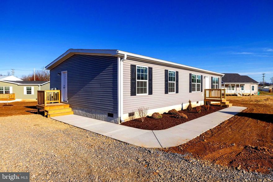 Experience modern comfort and quality craftsmanship in this brand-new 3-bedroom, 2-bath Beacon Prestige manufactured home by Cavco, ideally situated in the heart of the charming Town of Stanley. Offering approximately 1,380 square feet of thoughtfully designed living space, this home features a bright open-concept layout connecting the living room, dining area, walk-in pantry, and kitchen—perfect for everyday living and easy entertaining. The spacious kitchen includes stainless steel appliances, excellent counter space, and stylish cabinetry. The private primary suite offers a full bath and generous closet, while two additional bedrooms and a second full bath provide flexibility for guests, hobbies, or a home office. Built for efficient, low-maintenance living, the home includes durable finishes, energy-efficient appliances, and a heat pump. The level lot and back deck offer comfortable outdoor living with views of the surrounding mountains. Enjoy the best of small-town living—with local shops and restaurants, town parks, and seasonal events that bring everyone together. Stanley offers a peaceful pace of life while still being just minutes from Luray, the Shenandoah River, and Shenandoah National Park, making it ideal for those seeking both comfort and connection. With public water, sewer, trash collection, and no HOA, convenience and affordability come together seamlessly. A fantastic opportunity for buyers seeking a new, move-in-ready home with modern style, thoughtful design, and the welcoming charm of small-town Stanley.