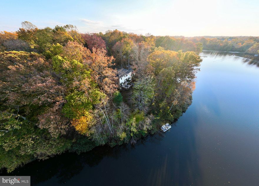 This exquisitely crafted WATERFRONT RESIDENCE is a RARE GEM, making its debut on the market for the first time since 1992! Offering an array of exclusive features, including a PRIVATE DOCK, Gazebo, and a PONTOON BOAT, one Kayak and two SUPs that ALL CONVEY to the new homeowner!  Distinguishing itself as a one-of-a-kind property in Montclair, it boasts SPECTACULAR PANORAMIC VIEWS OF THE LAKE (make sure to schedule your visit during daylight hours to soak in all the views!).  Nestled on a SERENE private street with only four residences, and West Beach just around the corner, this home exudes UNPARALLELED CHARM.  Upon first sight, this home's curb appeal is truly magazine-worthy, featuring a stunning brick facade, an ornate front door flanked by sidelights, inviting blue stone patios with bench seating, and expertly designed landscaping. A smart update by the homeowner includes the addition of a two-car garage at the street-facing entry level, while the original two-car garage at the rear of the home presents endless possibilities, from a workshop to a gym or recreational space. Stepping inside, the GRANDEUR is immediately apparent as you enter the regal 16 FOOT FOYER, adorned with gleaming hardwood floors, an elegant angled hardwood staircase, and a captivating chandelier that sets the tone for the entire home. The rear of the house is adorned with a breathtaking wall of windows, providing a unique perspective of the lake from among the treetops.  The heart of this residence is the exquisitely remodeled kitchen, where the large island takes center stage with custom cabinetry,  elegant quartz countertops and seating for the family. Doing dishes in the oversized porcelain sink while basking in the sunlight's reflection on the lake is a true delight. All kitchen appliances are stainless steel, with a brand new commercial-size refrigerator. A conveniently located wet bar, complete with a charming copper sink and faucet, houses a wine fridge and is graced with beautiful quartz countertops. The kitchen seamlessly flows into the expansive family room, featuring a striking brick hearth, a glass-enclosed fireplace, and a stunning wood mantel. Adjacent to the kitchen, a spacious Dining Room and an adjoining room that can serve as an office or a living room provide tranquil views of the front patio garden.  Ascending the stairs, you'll be captivated by the Primary Suite, which boasts a generous attached bath with a soaking tub, a walk-in shower, a dual-sink vanity, and more captivating views of the lake. A customized walk-in closet adds to the suite's appeal. Two additional sizable bedrooms share a spacious hall bath, and the convenience of a laundry room on this level is undeniable. The lower level is equally impressive, featuring a walk-out basement leading to an expansive stone patio. The fourth bedroom is graced with ample windows and an attached full bath, making it an ideal guest or au pair suite. Additionally, there is a spacious recreation room perfect for movie or game nights.  Access to the lower-level garage expands the possibilities for entertainment...even a ping pong table is included!  There's also more must=have unfinished storage space on this level  Residents of Montclair have access to a multitude of amenities, including a 109-acre stocked lake with three sandy beaches, a boat ramp, boat storage, fishing piers, playgrounds, tot lots, ball fields, exercise stations, and a new dog park. The community also boasts an 18-hole golf course with a full-service Country Club, and pool memberships are available. Convenient access to I-95 and nearby commuter lots and bus routes simplify commuting to DC, the Pentagon, and beyond. Special financing is available through Project My Home, offering potential savings on closing costs.   Additionally, the home is currently enrolled in a premium home warranty, which can be transferred to the buyer at closing.