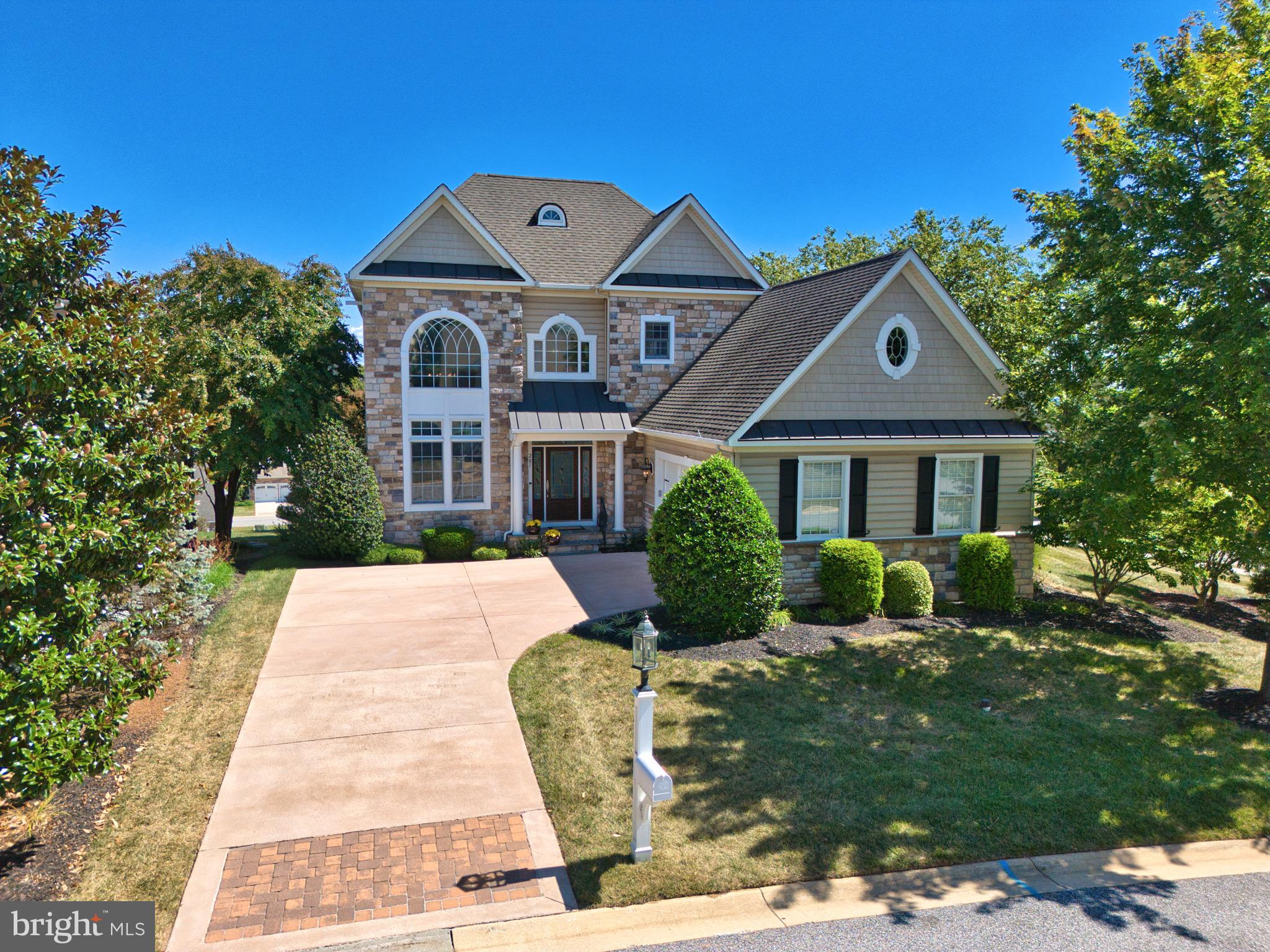 Welcome to 201 War Admiral Way, a stunning Colonial residence located in the highly sought-after gated community of Bulle Rock in Havre de Grace. Offering over 5,700 square feet of beautifully finished living space, this home blends timeless elegance with modern convenience. Inside, you’ll find 3 spacious bedrooms and 4.5 bathrooms, along with a thoughtful layout that is perfect for both everyday living and large-scale entertaining. The gourmet kitchen is the heart of the home, featuring dual center islands, granite countertops, upgraded cabinetry, and plenty of space for gathering. Formal living and dining areas showcase elegant moldings and rich finishes, and open directly to a private stone courtyard complete with a pergola, outdoor fireplace, and built-in grill—an entertainer’s dream. Upstairs, generously sized bedrooms offer comfort and privacy, while the lower level provides a true retreat with a custom wine room, full bar, home theater, recreation spaces, and direct walk-out access to the outdoors.
Every detail of this property reflects quality craftsmanship, from the crown molding and millwork to the well-planned flow of each room. The home also features an attached garage, a professionally landscaped lot, and a peaceful cul-de-sac setting within the community. Living at Bulle Rock means enjoying resort-style amenities including indoor and outdoor pools, a fitness center, clubhouse, tennis courts, walking paths, meeting rooms, and community events—all with the convenience of low-maintenance living. Perfectly situated near the Chesapeake Bay, historic Havre de Grace, and major commuter routes, this home offers the ideal combination of luxury, lifestyle, and location.