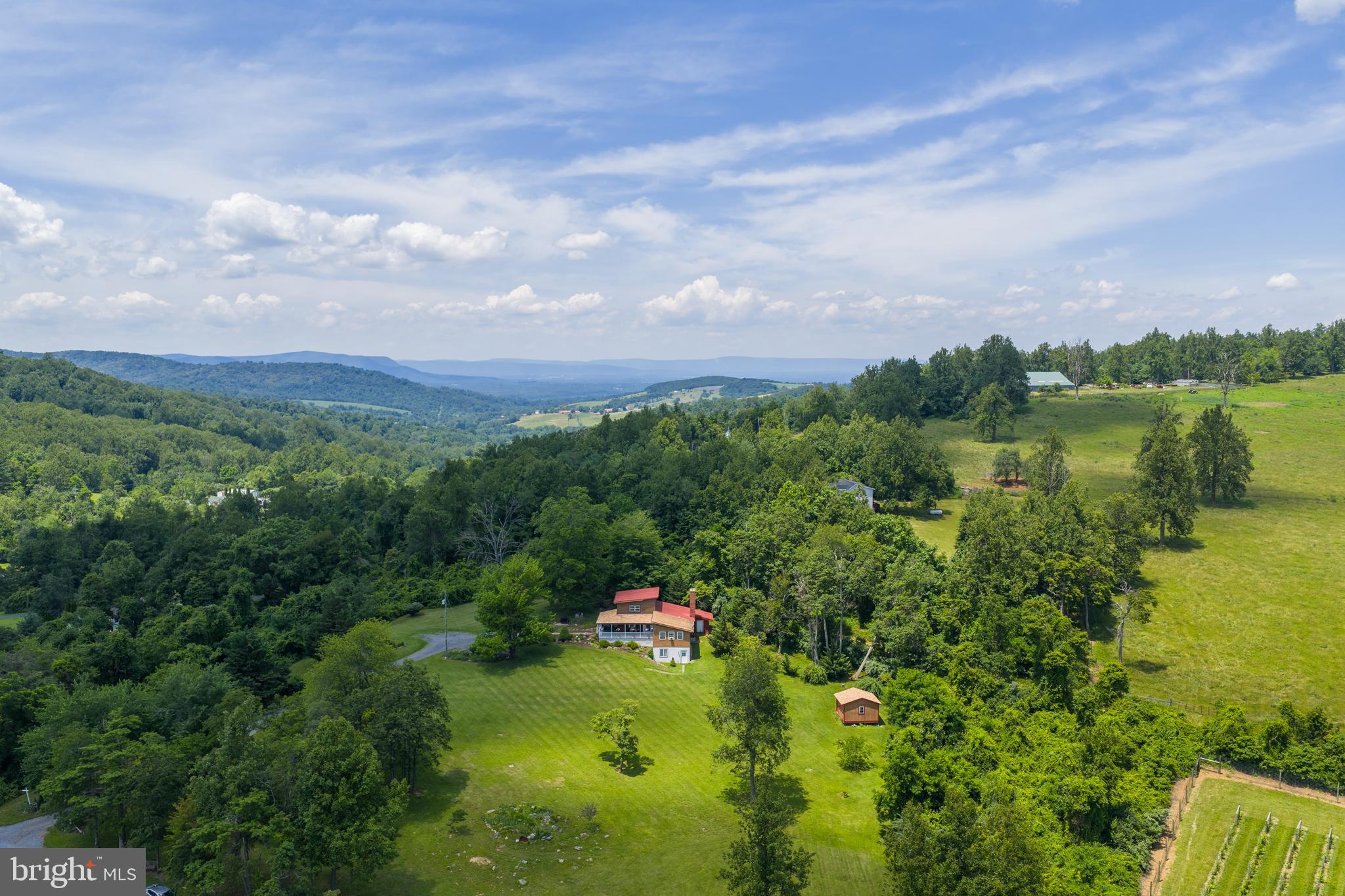 Welcome to your dream retreat! Nestled on over 6 acres of land with breathtaking mountain views, this charming 3 bedroom, 2.5 bath home is a serene escape from the everyday. As you approach the home, A covered front and side porch invite you to relax and enjoy the panoramic scenery—perfect for morning coffee or hosting guests throughout the day. Inside you’ll find the cozy kitchen, full of character, serving as the heart of the home, ideal for gathering and making lasting memories. The family room features a beautiful stone fireplace and wood-beamed ceiling, creating a warm ambiance. The main level also offers a spacious primary suite with its own private bath.
Outdoors, you'll be captivated by stunning mountain views and a stocked pond, perfect for year-round fishing. Enjoy ultimate privacy, with the property bordering several large tracts and a neighboring vineyard at Chester Gap Cellars. Whether you seek a peaceful weekend getaway or a full-time residence, this property’s agricultural zoning offers endless possibilities. Conveniently located just minutes from town, this private oasis awaits your personal touch, come fall in love and make it your own!