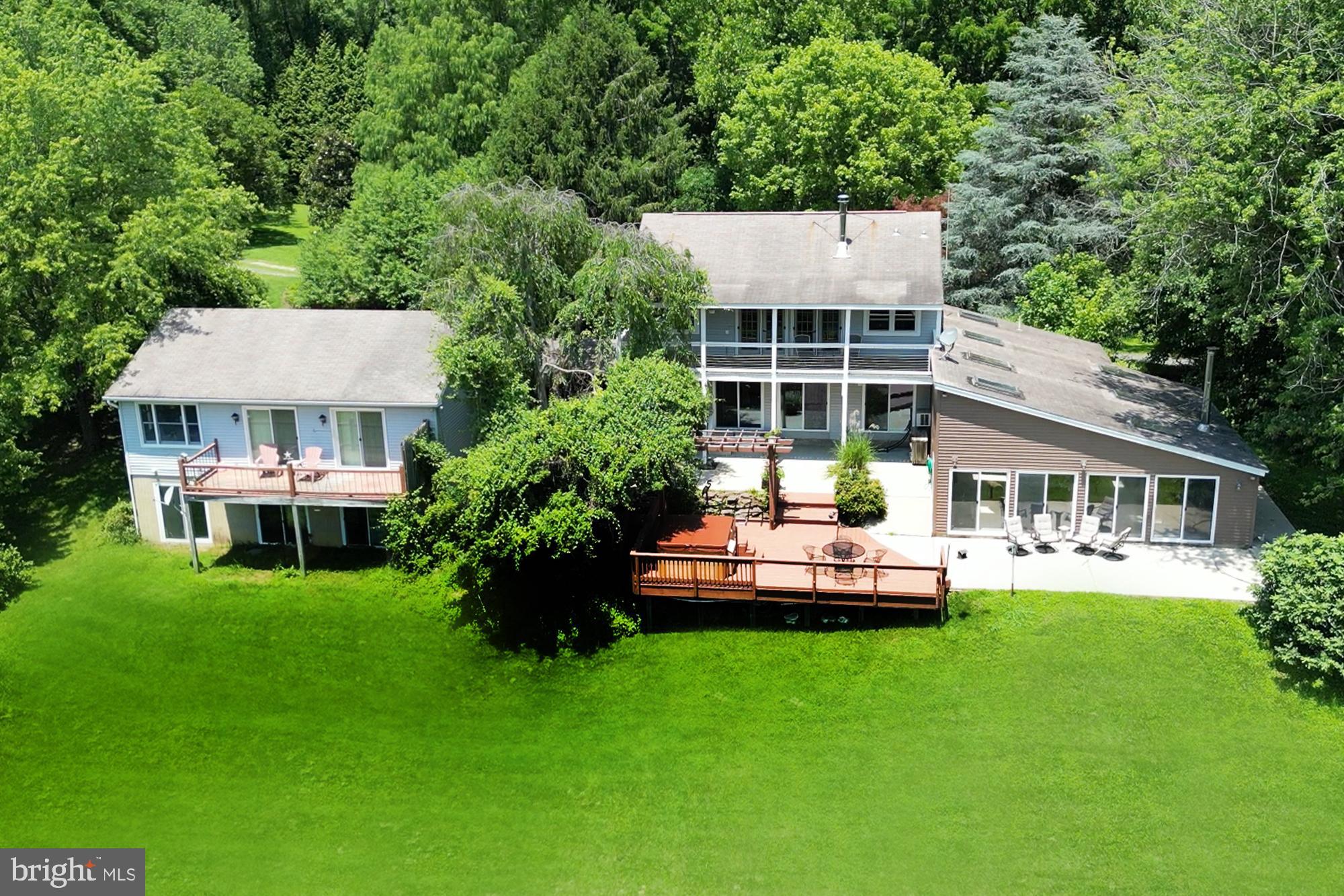 IDYLLIC FAMILY COMPOUND in BAY COUNTRY with a CONSERVATIONIST CALLING! BASK IN PASTORAL TRANQUILITY on this 21.46-ACRE FARM with charmingly renovated FARMHOUSE with Two Bedrooms and breezeway-connected separate COTTAGE / GUEST HOUSE also with two Bedrooms, both with decks/balconies gazing over protected woodland. (Forest Stewardship Plan squires 14.6 acres of woodland which affords a huge tax advantage along with 5.86 acres of fields!!!) The Main House (2BR/3BA) boasts organic wood plank ceilings, paneling, trim, & floors. Walls of glass frame sweeping views of lush wooded environs, home to local wildlife in their natural, undisturbed habitats. Gather in the vaulted lodge-style Rec Room opening to patio or the Great Room combining living/dining/cooking areas sharing wood stove ambiance and an alfresco dining/hot tub relaxation deck! The upper level Primary Bedroom Suite is a retreat in itself with sitting room & treetop balcony perched for birdsong serenades. The Cottage (2BR/1BA) is self-sufficient and quaint with an open concept floor plan combining living/dining/cooking areas and and raised balcony to celebrate the seasons. Each home offers renovated Baths, a Laundry Room, unfinished basement storage, and huge multi-vehicle parking court. Close to West River & Bay boating, daily catch eateries, parks, farmers’ markets, and RTs 301/214/50. 20 Minutes to Annapolis; 40 minutes to Baltimore & D.C. AN ENRICHING SENSE of SERENITY, SECURITY, and STEWARDSHIP!!
