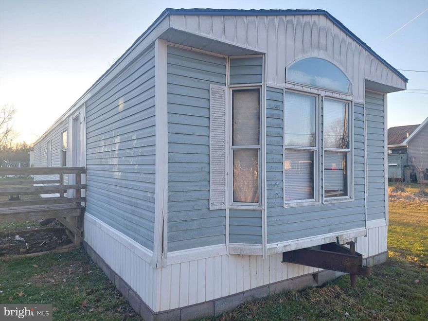 Here in the small town of Wardensville, West Virginia, is a single-wide mobile home awaiting a new owner's touch. This property presents a promising opportunity for those skilled in repairs and renovations.  2 bedrooms 1 full bath, large kitchen and living room, separate laundry room.  The GOOD:  Seller replaced roof in 2022, exterior is satisfactory condition, good location in walking distance to shopping, dining.  The BAD:  In need of attention are windows, flooring, HVAC system, and appliances.    With the right expertise and vision, this mobile home has the potential to become a cozy, inexpensive home or investment property. Don't miss out on the chance to transform this fixer-upper into a comfortable haven in Wardensville.  Cash or conventional financing only!