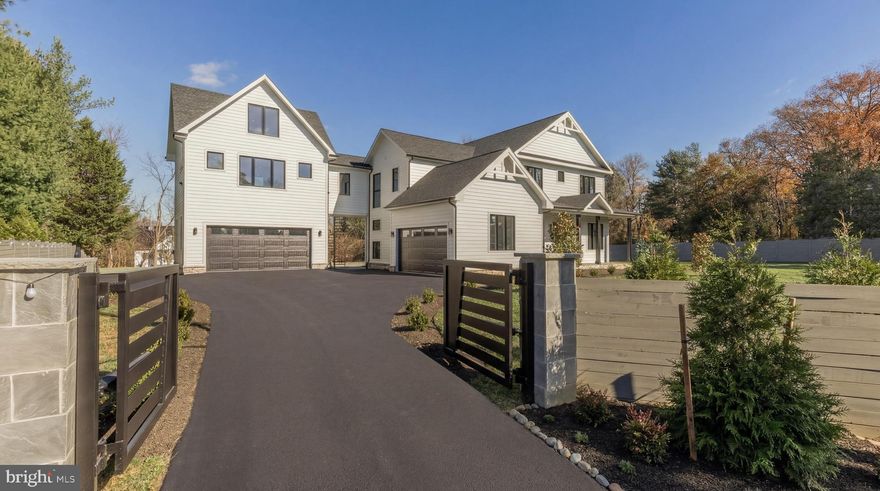 Set behind a private electric gate on a beautifully landscaped acre, Esworthy Road presents a thoughtfully designed estate that balances privacy, scale, and everyday livability. The property is composed of a three-bedroom main residence, a fully equipped guest house, and a detached studio, offering a rare level of flexibility to accommodate a variety of lifestyles.

A welcoming front porch introduces the main residence, where the interior opens into a light-filled main level defined by 10-foot ceilings, wide-plank hardwood flooring, and a seamless, open flow. The layout is anchored by a spacious central living area that connects effortlessly to the kitchen and dining spaces, creating an ideal environment for both daily living and entertaining.

The kitchen is designed with both function and presentation in mind, featuring an expansive center island, full-height quartz surfaces, custom cabinetry, and a complete Thermador appliance suite. It opens naturally to the surrounding living areas, allowing for easy interaction and a cohesive sense of space.

Upstairs, the primary suite offers a quiet retreat with a tray ceiling, two walk-in closets, and a well-appointed bath complete with dual vanities, a walk-in shower, private water closet, and a freestanding soaking tub. Two additional bedrooms each feature en-suite baths and walk-in closets, providing comfort and privacy for family or guests.

The fully finished lower level expands the home’s versatility, offering a large recreation area with a modern fireplace, a dedicated fitness space, an additional bedroom, and a full bath.

The guest house is equally well-considered, offering independent living with its own HVAC system, water heater, and laundry connections. With space for a full kitchen, a bedroom, full bath, and open living area, it serves seamlessly as an in-law suite, au pair residence, private office, or extended guest accommodations.

A separate detached studio provides additional flexibility, ideal for creative use, a gym, or a quiet workspace.

Outdoor living is just as compelling, with a semicircular bluestone patio extending from the home into the surrounding landscape, creating a natural setting for dining and entertaining. The yard is level, expansive, and fully fenced, offering both privacy and usability.

Additional features include a four-car garage with EV charging, a high-efficiency septic system, and a private well.

With its combination of thoughtful design, functional layout, and multiple living structures, Esworthy Road offers a rare opportunity for flexible, refined living in a private setting.