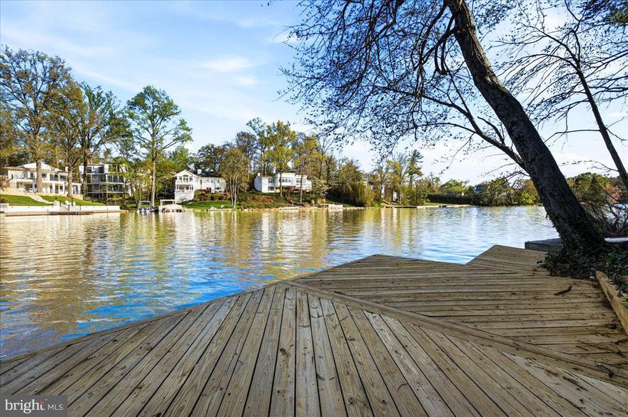 PRICE IMPROVEMENT! LAKE BARCROFT  WATERFRONT - With sweeping lake views from nearly every room, this 4BR/3BA Mid-Century Modern home  with 150+ feet of pristine shoreline is a rare waterfront offering! Tucked among the trees on a quiet cul-de-sac and set on almost half an acre, it lives like a private retreat, perched above the water with a true treehouse feel.

A slate walk leads to double doors and into a light-filled foyer. Cathedral ceilings soar above the main living space, where a wall of glass frames the lake and brings the outdoors in. Hardwood floors, skylights, and clean contemporary lines highlight the home’s architectural character. The updated kitchen features  granite counters and a breakfast bar, and opens to the family room with fireplace with sliding doors leading to the upper deck, creating an easy, open flow for everyday living and entertaining. A main-level bedroom and full hall bath offer flexibility for guests or office space.

Downstairs, the spacious ensuite primary suite opens directly to the lower level deck and water views beyond, and includes a private sitting/dressing area and updated bath. This level also features the third bedroom, fourth bedroom/recreation room with fireplace, an updated hall bath, laundry, and a bonus room—ideal for hobbies, workouts, or extra storage.

Multiple decks invite you to unwind with morning coffee or sunset dinners overlooking the lake. Swim, fish, or paddle from your private dock, and enjoy landscaped grounds with mature trees and seasonal blooms. A semi-circular driveway and attached two-car garage add everyday ease.

Waterfront living, timeless mid-century design, and an unmistakable sense of calm—this is Lake Barcroft at its best.