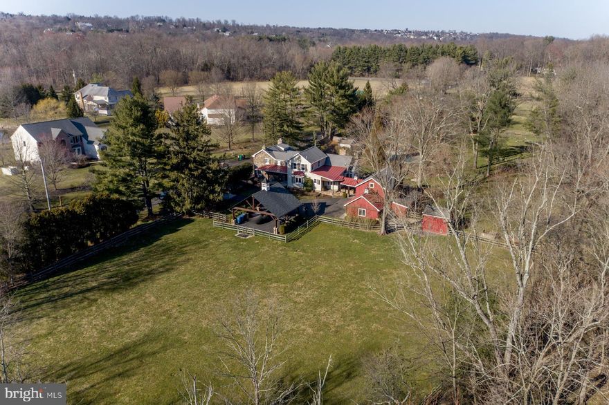 Exquisite, Bucks County farmhouse offers old world charm with luxury amenities. The beautiful stone 1860 era main house is magnificently restored and features pumpkin pine wide plank flooring, walk in fire place, tin and wood beamed ceilings and exposed stone walls.   The expansive addition blends seamlessly with the original house and features a spacious dream chef’s kitchen, with oversized stain concrete island, built in gourmet cooktop, DBL oven and plenty of custom cabinetry. The large breakfast area overlooks the great room with cathedral ceiling and a floor to ceiling stone fire place surrounded by windows. The first floor main suite features, a large walk in shower, double vanity, custom closet and a picture window which overlooks the garden and salt water pool. Upstairs, there is princess suite, two additional bedrooms, bath, loft area and a laundry room.  The finished walk-out daylight basement with an additional bedroom and full bath as well as a large storage area.  This meticulously maintained property is fully landscaped, with a renovated barn that offers 2 car parking, work shop area and fully conditioned loft area for further entertaining. There is a large architecturally designed carport for additional parking.  The pool area is surrounded by a large patio, separate spa and pool house.  This unique Bucks County farmhouse will not disappoint!
