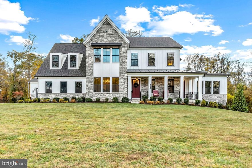 Wind through a park-like setting to reach Kingsley Woods, the recently completed and highly sought-after community in the center of Howard County and adjacent to some of the finest schools in the state. There is a strong and welcoming community here, but social connection is well-balanced with the calming sights and sounds of surrounding nature and forestry. This exceptional home sits on a premium lot bordered by forest conservation and spans 8,466 finished square feet, offering plenty of space and a flexible layout for multigenerational living, multiple offices, play spaces, a music or art studio, and a home gym. Every room exudes elegance, with designer lighting, engineered hardwood floors, custom millwork, and expansive windows that fill the home with natural light.

The grand foyer opens to a formal dining room with wall sconces and a sparkling chandelier, while French doors reveal a private study. The great room impresses with 20’ ceilings, a gas fireplace with a wood mantel and marble surround, and custom built-ins. Multi-panel stacking doors lead to the covered deck, which converts to a screened-in porch via a fully integrated remote-controlled screen, complete with a stone gas fireplace and ceiling fan for year-round use. An extended custom Trex® deck enhances the indoor-outdoor entertaining space.

The gourmet kitchen features stainless steel appliances, including a Wolf six-burner cooktop, dual-fuel range with touch-screen controls, an infrared griddle, and a 48” Sub-Zero refrigerator. A walk-in pantry and butler’s pantry offer generous storage. Silestone quartz countertops, floor-to-ceiling subway tile, and a large island with pendant lighting and breakfast bar seating anchor the space. White perimeter cabinetry with under-cabinet lighting contrasts beautifully with the warm walnut island, and a sunlit breakfast area completes the kitchen. A multi-generational suite with a private entrance includes a living room, a bedroom with a walk-in closet, a spa-like full bath with dual vanities, a freestanding tub, a glass shower, and a laundry room with hookups. A main-level bedroom or bonus room provides added flexibility, complete with a dual-vanity ensuite bath and walk-in closet. An elegantly wallpapered powder room with a Toto® bidet and a spacious mudroom with a walk-in closet lead to the Wi-Fi-enabled garage.

Upstairs, a loft with built-in bookcases serves as a cozy lounge. The primary suite offers plush carpeting, blackout shades, and a large walk-in closet. Its spa-inspired bathroom includes a glass steam shower with rain and handheld heads, herringbone tile floors, dual Calacatta marble vanities, a freestanding tub, a bidet, and a dual towel warmer. Each of the three secondary bedrooms has an en suite bath and a walk-in closet.

The uppermost level offers flexible finished attic space with LVP floors, a half bath, and storage—nicknamed “the sleepover room,” but ideal as a bedroom, office, playroom, or recreation area.

The finished walk-out lower level includes a large open space with a wet bar, a beverage refrigerator, a dishwasher, a full bathroom, and a bedroom with a walk-in closet—perfect for a gym, guest suite, or hobby room. Two utility rooms and a storage area complete the interior.

The expansive backyard provides endless potential for resort-style living. A comprehensive landscape plan by a renowned landscape architect outlines possibilities for an 18’x42’ pool, spa, patio, cutting garden, and custom hardscaping.

Within three miles, major shopping centers offer groceries, dining, and essentials. Centennial Park, just two miles away, provides a lake, playgrounds, sports courts, and paths. Residents benefit from top-rated Howard County schools and quick access to Route 40, Route 29, and I-70 for seamless travel.