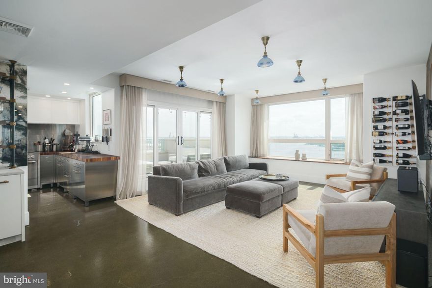 Corner PENTHOUSE apartment at The Residences at Dockside. Enjoy urban waterfront condo living in this exceptional open floor plan home. This apartment has been totally renovated, in pristine condition with spectacular water views from every window of the Delaware River, Benjamin Franklin Bridge and walking trail at Penn's Landing. This property is bright and spacious (1,845 SqFt), 3 bedrooms, 2.5 baths and 2 DEEDED indoor PARKING SPACES, high ceilings, polished concrete floors and custom recessed lighting. Custom draperies and shades throughout. Entry to large living room/dining room with wonderful unobstructed water views. Access from living room, dining room and kitchen to dramatic wrap around terrace (approx. 15'x18') through double glass doors. Very sophisticated cook's kitchen with butcher block and marble countertops, stainless steel cabinetry, stainless dishwasher, AGA Mercury 5-burner induction stove with double ovens, SUBZERO refrigerator and excellent storage. Custom built-in marble bar with 2 wine refrigerators, ice maker and a pass-through to kitchen. Lovely powder room and utility/coat closet. Spacious primary bedroom with double glass doors to South-facing terrace and luxurious en-suite marble bath with double shower, double sinks and custom cabinetry. Huge walk-in custom closet. (Door to primary bedroom will be replaced to match existing doors). Full-sized Electrolux washer and dryer included and linen closet. Extraordinary light and water views from all 3 bedrooms. All bathrooms are marble and have TOTO toilets. 2 additional large bedrooms with excellent closets. One bedroom has been opened for use as an exercise room. The amenities include complimentary visitor parking, shuttle service in addition to excellent security, concierge, fitness center, indoor swimming pool, hot tub, club house and large landscaped terrace overlooking the river - all included in the association fee.