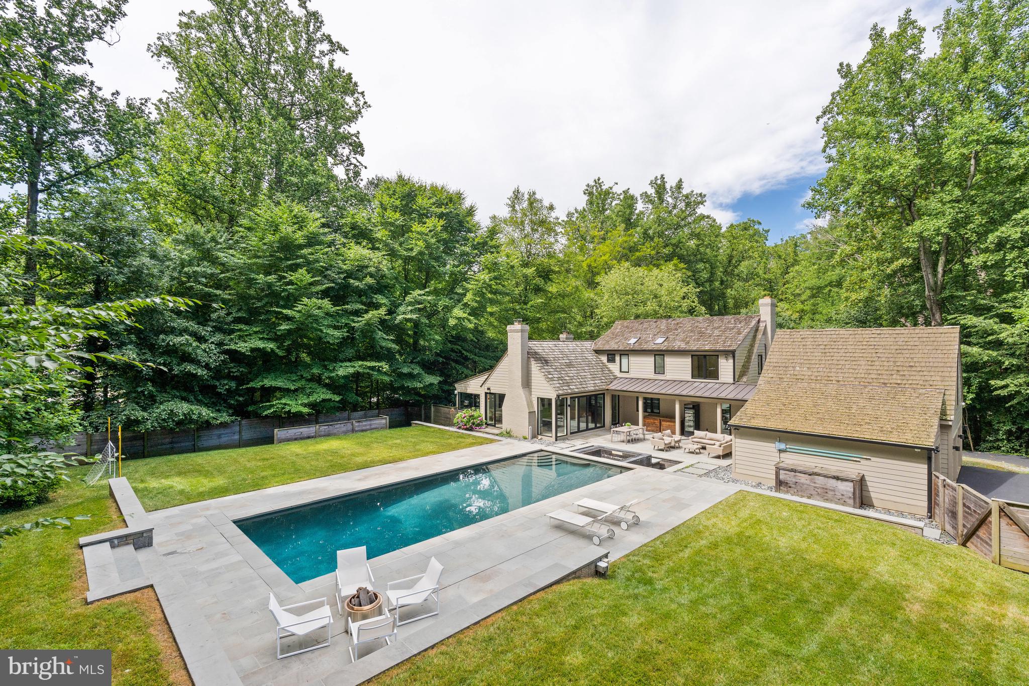 Welcome to this masterfully renovated home on almost an acre in Bethesda’s sought-after Bradley Hills Grove neighborhood! Both the interior and exterior provide limitless opportunities for large-scale entertaining or more intimate family gatherings.
The carefully thought-out renovation is clearly reflected in the open floor plan, which allows for a seamless flow among the main level’s spacious and light-filled rooms, which include a Living (or Music) Room with gas fireplace and Dining room, both of which have large windows overlooking the beautiful, treed lot; and a private den/office with built-ins. The Great Room with 13’-high cathedral ceiling features a floor-to-ceiling stone wood-burning fireplace and a beautiful butterfly glass wall that opens to the pool, patio, spa and breezeway. An atrium door leads directly to the breezeway and three-car garage. The Gourmet Kitchen with floor-to-ceiling cabinetry and a center island provide wonderful space for even the most accomplished cook The Kitchen and Informal Eating Area each have 13’ ceilings with three skylights. There is also an atrium door to the backyard.
If a first-floor Primary Bedroom Suite is on your wish list, this one is sure to delight! The Bedroom has two floor-to-ceiling windows overlooking the treed lot and a large, fully organized walk-in closet with an atrium door for easy access to the back yard. The Primary Ensuite Bathroom with oversized shower, custom glass door, and oval stand-alone tub also has two floating vanities with marble counters, mirrors, and custom lighting.
A special highlight of the first floor is the beautiful, architect-designed staircase with glass, wood, and steel that leads to the upper level. The second floor has three large bedrooms, one of which has a secret Playroom! Another has its own ensuite full Bathroom with skylight and tub/shower. There is a hall Bathroom as well.
The walkout lower level provides endless possibilities! The large Family Room has a tile wall with wood-burning fireplace and large-screen TV. Exercise aficionados will delight in the gym with a mirrored wall and exercise equipment, TV, and media closet, and refrigerator-freezer, all of which will convey. A fourth full Bath is adjacent to the Gym. There is also a separate Laundry Room with built-in counter with sink and cabinets, and drawers plus G.E. front-load washer and dryer with drawers below. The Utility Room houses two 75-gallon hot water heaters and Carrier furnace for the three heating/AC zones in the house.
The outside is equally extraordinary! The large saltwater pool with electric cover surrounded by an extensive patio is a wonderful place to relax. The adjacent hot tub has a recirculating fountain. And there is still plenty of yard to enjoy outdoor games or just lounging!
Located close to downtown Bethesda’s numerous dining, shopping, and entertaining opportunities, it also enjoys easy access to all that our Nation’s Capital has to offer, as well as Northern Virginia and the area’s three major airports.
Yes, you can have it all!