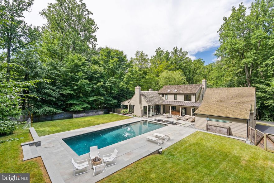 Welcome to this masterfully renovated home on almost an acre in Bethesda’s sought-after Bradley Hills Grove neighborhood! Both the interior and exterior provide limitless opportunities for large-scale entertaining or more intimate family gatherings.
The carefully thought-out renovation is clearly reflected in the open floor plan, which allows for a seamless flow among the main level’s spacious and light-filled rooms, which include a Living (or Music) Room with gas fireplace and Dining room, both of which have large windows overlooking the beautiful, treed lot; and a private den/office with built-ins. The Great Room with 13’-high cathedral ceiling features a floor-to-ceiling stone wood-burning fireplace and a beautiful butterfly glass wall that opens to the pool, patio,  spa and breezeway. An atrium door leads directly to the breezeway and three-car garage. The Gourmet Kitchen with floor-to-ceiling cabinetry and a center island provide wonderful space for even the most accomplished cook The Kitchen and Informal Eating Area each have 13’ ceilings with three skylights. There is also an atrium door to the backyard. 
If a first-floor Primary Bedroom Suite is on your wish list, this one is sure to delight! The Bedroom has two floor-to-ceiling windows overlooking the treed lot and a large, fully organized walk-in closet with an atrium door for easy access to the back yard. The Primary Ensuite Bathroom with oversized shower, custom glass door, and oval stand-alone tub also has two floating vanities with marble counters, mirrors, and custom lighting.
A special highlight of the first floor is the beautiful, architect-designed staircase with glass, wood, and steel that leads to the upper level. The second floor has three large bedrooms, one of which has a secret Playroom! Another has its own ensuite full Bathroom with skylight and tub/shower. There is a hall Bathroom as well.
The walkout lower level provides endless possibilities! The large Family Room has a tile wall with wood-burning fireplace and large-screen TV. Exercise aficionados will delight in the gym with a mirrored wall and exercise equipment, TV, and media closet, and refrigerator-freezer, all of which will convey. A fourth full Bath is adjacent to the Gym. There is also a separate Laundry Room with built-in counter with sink and cabinets, and drawers plus G.E. front-load washer and dryer with drawers below. The Utility Room houses two 75-gallon hot water heaters and Carrier furnace for the three heating/AC zones in the house.
The outside is equally extraordinary! The large saltwater pool with electric cover surrounded by an extensive patio is a wonderful place to relax. The adjacent hot tub has a recirculating fountain. And there is still plenty of yard to enjoy outdoor games or just lounging!
Located close to downtown Bethesda’s numerous dining, shopping, and entertaining opportunities, it also enjoys easy access to all that our Nation’s Capital has to offer, as well as Northern Virginia and the area’s three major airports.
Yes, you can have it all!