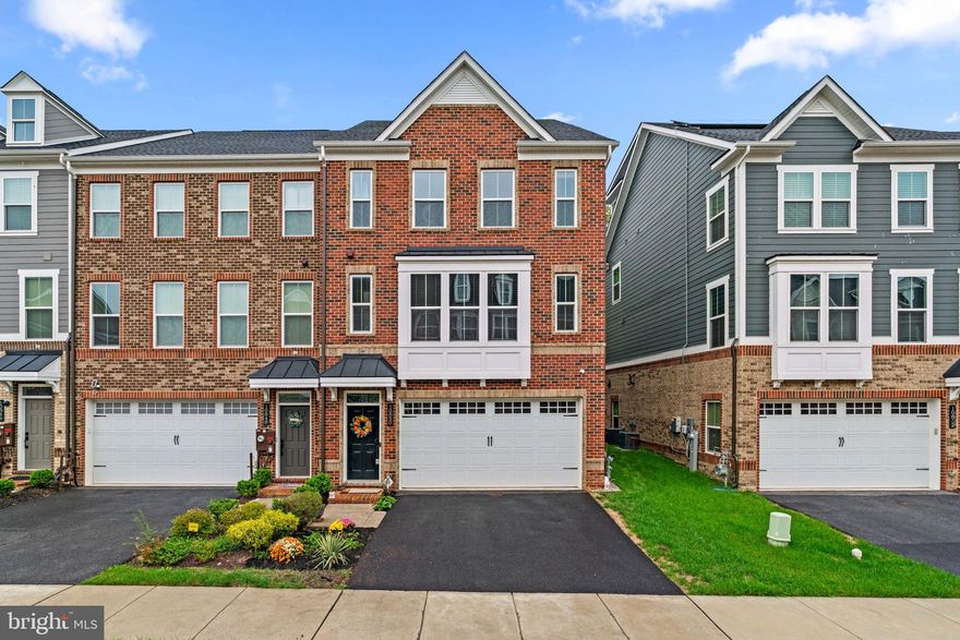 Stunning end-of-group townhouse offering 2,804 square feet, 4 bedrooms, 3 full baths, 1 half bath, and a 2-car garage in Greenleigh at Crossroads. Step inside the beautifully updated interior, beginning on the entry-level foyer with a built-in bench seat and lower storage. Find a fully finished recreation room with rear access, a private bedroom with a large closet, and a dual-access full bath, ideal as a guest suite. Upstairs, the bright and open main level showcases stylish LVT flooring throughout. The sunlit living room, complete with a convenient powder room, flows seamlessly into the upgraded eat-in kitchen. The kitchen offers quartzite counters, a classic subway tile backsplash, a pantry, and stainless steel appliances, including a double oven and smart-enabled dishwasher. An oversized island with breakfast bar seating and pendant lighting anchors the space, while a breakfast area with a coffee bar opens to the balcony overlooking the tree-lined backyard. The upper level hosts three spacious, carpeted bedrooms and two full baths. The primary suite includes a ceiling fan, a bath with a dual-sink vanity, and an upgraded frameless shower. The two additional bedrooms include rough-ins, making it easy to add ceiling fans. This level also features a convenient laundry room with custom shelving installed. Modern updates throughout the home include a UV light air filter, whole-house humidifier, sump pump battery backup, smart-enabled front washer and dryer, smart-enabled garage, Nest® thermostat, Ethernet ports in every room, video doorbell, and a security system that detects carbon monoxide, smoke, and water leaks. The 2-car garage is outfitted with sealed flooring, built-in storage shelves, laundry shelves, and an EV port. Community amenities include a clubhouse with a fitness center and yoga studio, a pool, multiple tot lots, a secured dog park, and scenic trails. The location offers convenient access to a MARC Station, major highways, and Baltimore City.