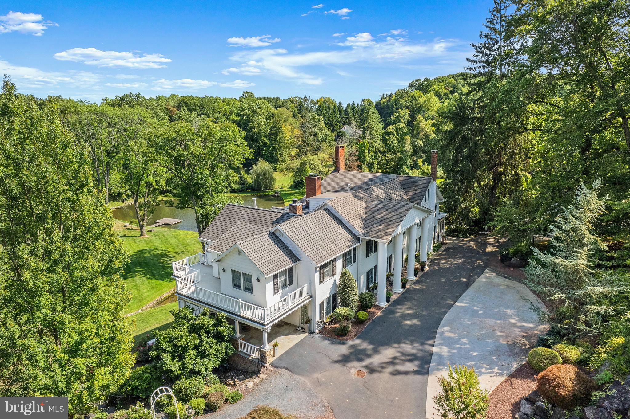 Welcome to Glenloch Manor, an exquisite estate property that has been completely transformed into a quinessential “ family compound” ! Behind the wrought iron gates is a masterfully planned Main House that has been thoughtfully restored, a spacious and modern Guest Cottage, a Luxury Party Barn, and Retro-style Pool House all positioned around a picturesque heart shaped pond. The magnificent Main Home demonstrates a Greek revival style with stately columns and has been completely renovated while celebrating its historic origin. A state-of-the-art addition highlights a dream Gourmet Kitchen with multiple islands, radiant heated floors, high-end appliances, and breathtaking views of the 11-acre compound. The main level features an open concept living and dining experience with custom bar uniting the rooms while maintaining the charm of both formal and informal spaces in the original section of the home. The upper level showcases an incredible Primary Suite that includes a dream closet with laundry, cozy sitting room, separate Study with balcony access and gas fireplace and a showstopping bath that is what dreams are made of demonstrating a floating dual vanity and spacious walk-in shower. Lavish in the freestanding tub while admiring the spectacular grounds. 4 additional bedrooms provide ample sleeping quarters or guests can experience privacy in a separate 2-bedroom Cottage equipped with wonderful amenities including a Sunroom, beautiful Gourmet Kitchen and access to outdoor space. The Luxury Barn is next level and offers an incredible opportunity to host many celebrations or simply enjoy a retreat with it’s fantastic, reclaimed finishes, bar, full kitchen, wood-burning stone fireplace, full bath, and cigar room, making it a truly enjoyable and unique dwelling. Additional benefits include Newly renovated Bathrooms, New Heating system, cost saving solar array, freshly painted exterior, wine cellar and more! The property is centrally located to the shopping and dining of New Hope, Doylestown and Newtown and major roadways for ease of commuting. Whether you fish off the dock in the aerated pond or bask in the sun by the pool, there is so much to experience at this phenomenal estate with all the accoutrements one can desire.
